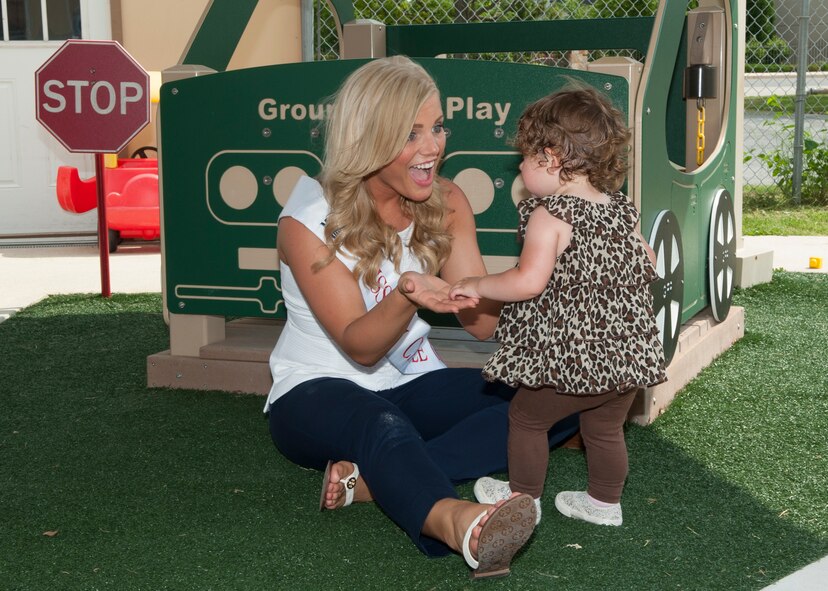 Mikaila Ryan, Miss Newark, plays with a toddler during a Miss Delaware contestant tour June 10, 2014, at the Child Development Center on Dover Air Force Base, Del. Visiting Dover AFB is an annual tradition for the Miss Delaware contestants. (U.S. Air Force photo/Airman 1st Class Zachary Cacicia)