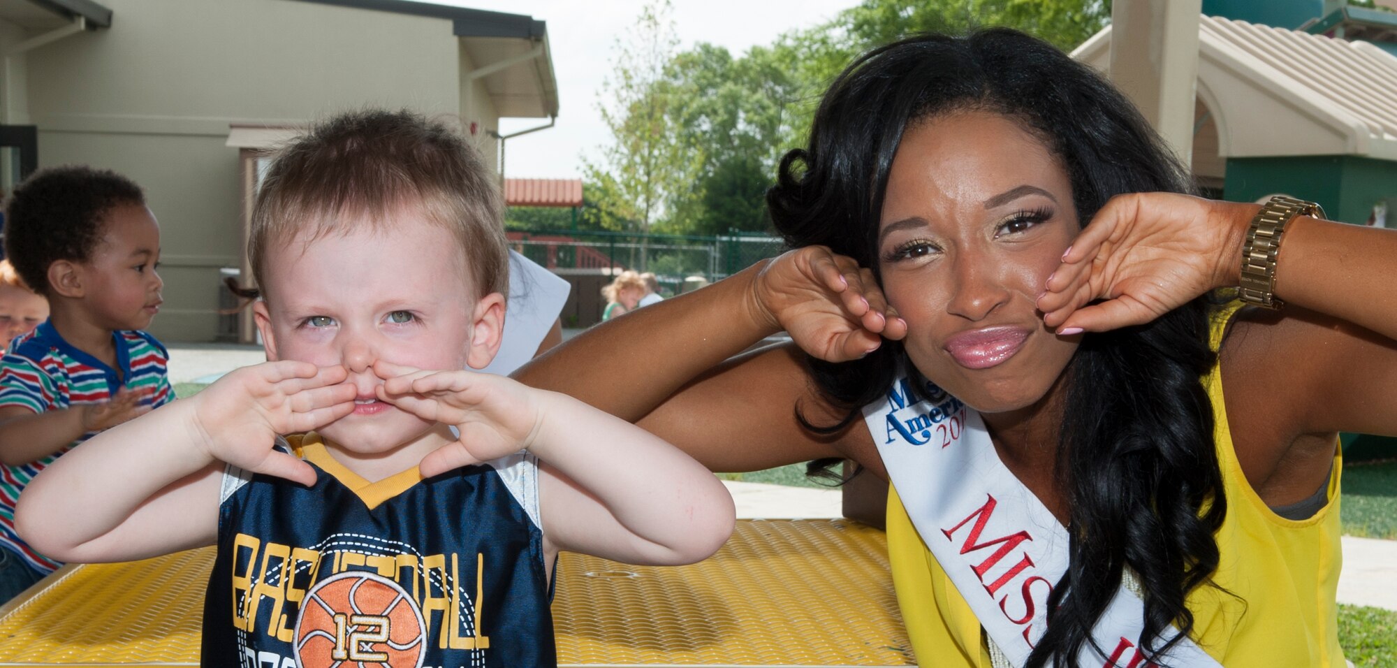 Brittany Lewis, Miss Wilmington, poses with a young boy during a Miss Delaware contestant tour June 10, 2014, at the Child Development Center on Dover Air Force Base, Del. The Miss Delaware Scholarship Organization provides thousands of dollars in scholarships each year to its many contestants. (U.S. Air Force photo/Airman 1st Class Zachary Cacicia) 