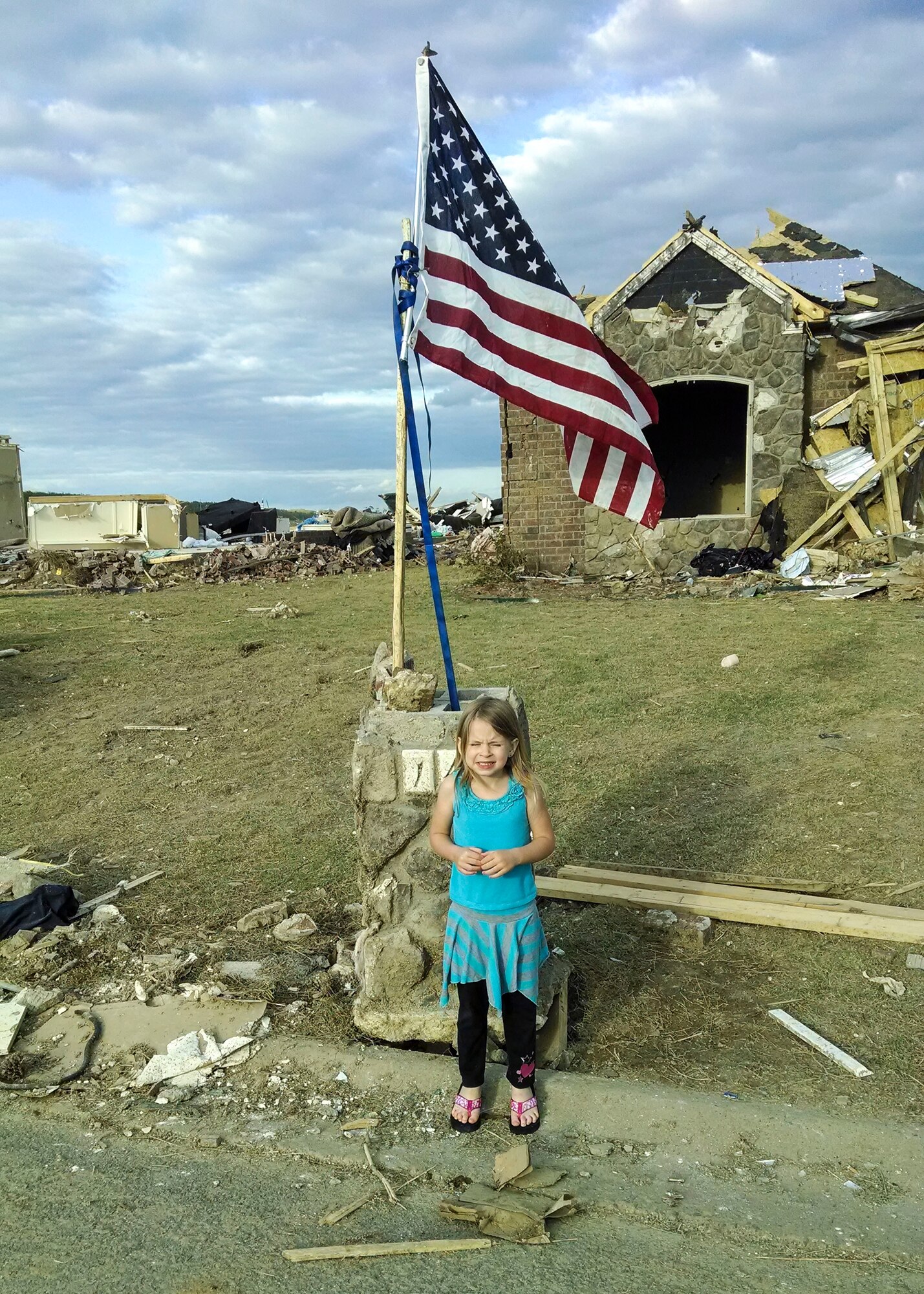 Ashleigh, 5, daughter of Staff Sgt. Mark Lewandowski, a 19th Maintenance Squadron aircraft fuels systems craftsman, stands front of what was once her home before the EF-4 tornado that killed 16 people in Vilonia, Ark., April 27. Little Rock Air Force Base and the local community supported the Lewandowski family with numerous donations including, gift cards, money, clothes, diapers and toys for their two children. (courtesy photo)
