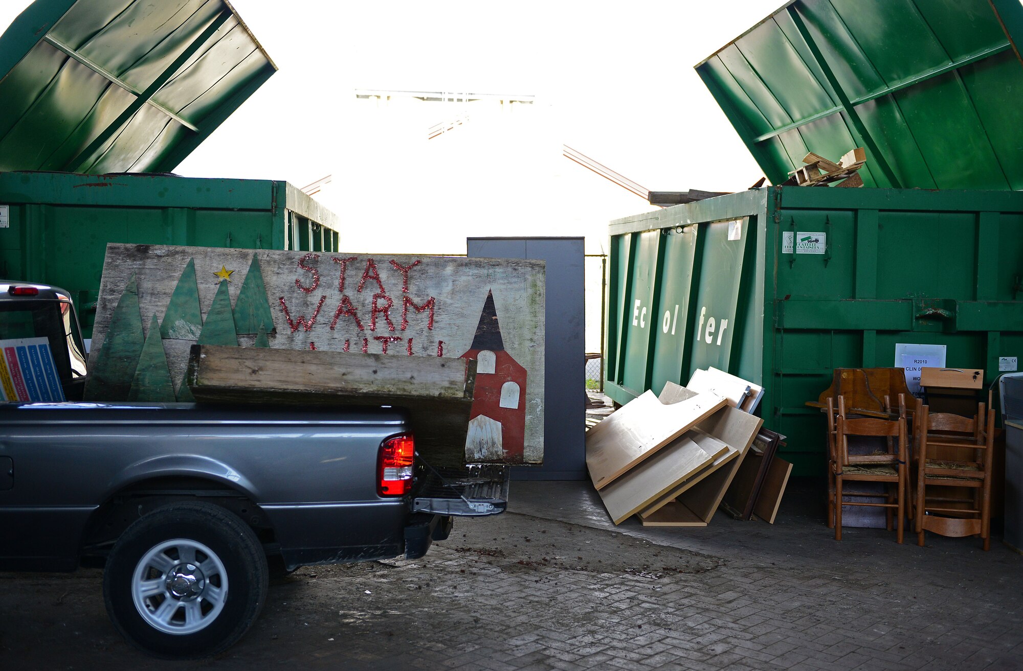 Staff Sgt. Christopher Callan, 31st Fighter Wing Chaplain Office, drives up to dispose of old wood during a base-wide spring cleaning event, May 30, 2014, at Aviano Air Base, Italy. More than 100 Team Aviano vehicles were loaded with government property and unwanted office supplies and discarded into 17 large green containers labeled for items such as batteries, computers, monitors, cords, any metal or plastic, toner cartridges and wood. (U.S. Air Force photo/Senior Airman Matthew Lotz)