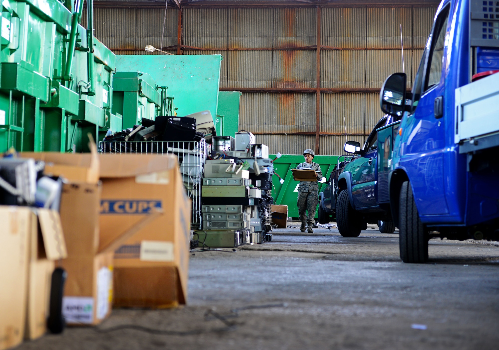 Senior Airman Danielle Ramsey, 31st Communications Squadron, carries a box of cords during a base-wide spring cleaning event, May 30, 2014, at Aviano Air Base, Italy. The cleanup accumulated approximately 142,815 pounds of scrap weight and provided squadrons around the base a chance to properly dispose of government property they no longer needed. (U.S. Air Force photo/Senior Airman Matthew Lotz)