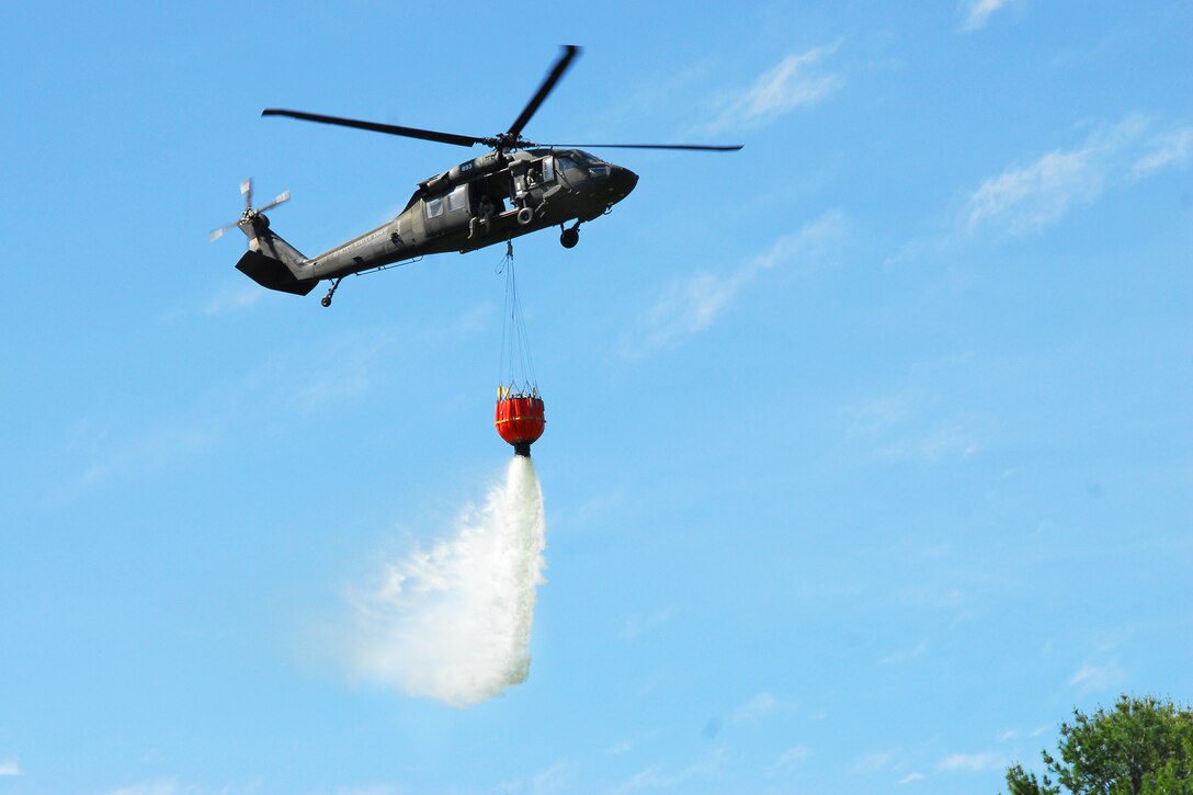 A UH-60 Black Hawk helicopter releases water from a Bambi bucket during training at the Round Lake Municipal Airport, N.Y., June 4, 2014.