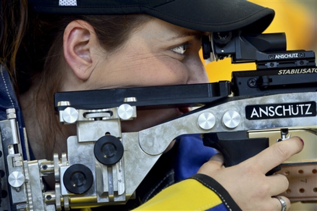 Navy Chief Petty Officer Jeannette Tarqueno fires an air rifle during the 2014 Wounded Warrior Team Navy Trials in Norfolk, Va., June 3, 2014. About 70 seriously wounded, ill and injured sailors and Coast Guardsmen from across the country are competing for a place on Team Navy 2014. 