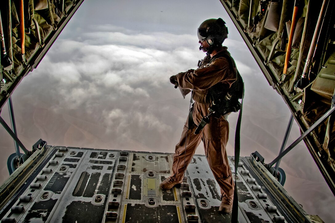 U.S. Air Force Tech. Sgt. Gabriel Campbell looks out on the bay of a C-130J Hercules aircraft before releasing pallets of cargo during an airdrop over Afghanistan, Nov. 7, 2011. Campbell is a load master assigned to the 772nd Expeditionary Airlift Squadron.  
