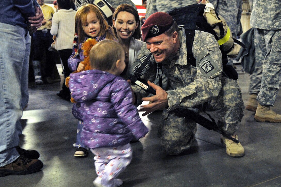 Army Staff Sgt. Michael Bernquist holds his arms out for his daughter, Evelyn, center, during a welcome home ceremony on Fort Bragg, N.C., Nov. 4, 2011. Bernquist is assigned to the XVIII Airborne Corps and just returned from a 12-month deployment in Iraq.  
