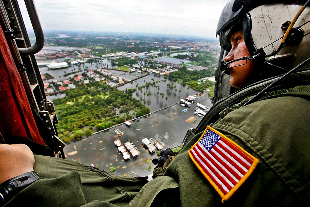 U.S. Navy Chief Petty Officer Nick Hall surveys flooded neighborhoods during an aerial assessment of Pathum Thani, Sai Mai, and surrounding areas north of Bangkok, Oct. 28, 2011. Hall is a search and rescue corpsman assigned to Helicopter Anti-Submarine Squadron, and a member of the III Marine Expeditionary Force's humanitarian assistance survey team. An abnormal monsoon season has caused flooding which has affected 61 provinces and 8.2 million people.  
