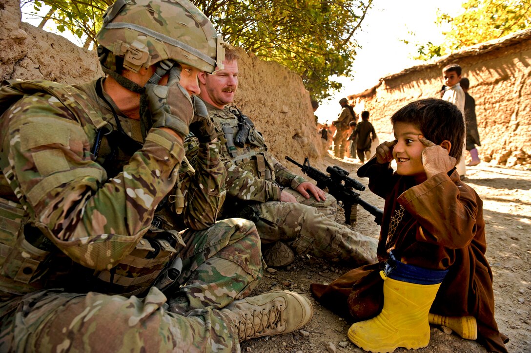 U.S. Air Force Capt. (Dr.) Michael Madsen plays with an Afghan child during a visit to his village in Zabul province, Afghanistan, Oct. 26, 2011. Madsen is the senior medical officer assigned to Provincial Reconstruction Team Zabul.  
