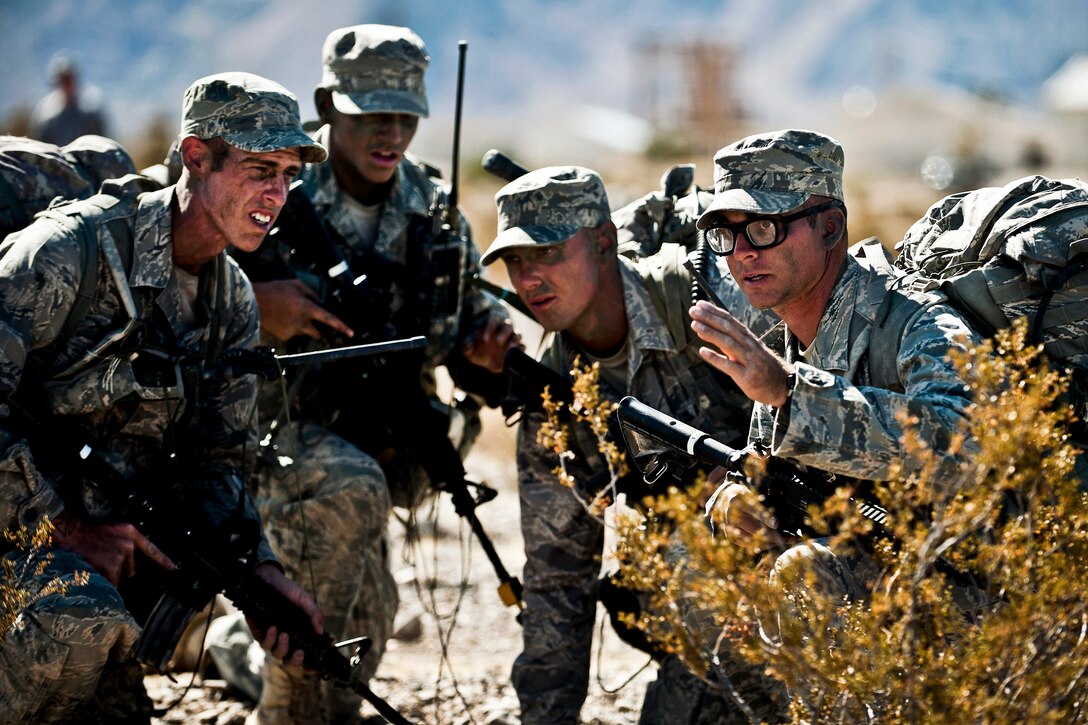 Air Force airmen training as squad leaders discuss tactics before an ambush training mission during a ranger assessment and selection course at the Nevada Test and Training Range on Nellis Air Force Base, Nev., Oct. 21, 2011. Airmen must attend the course before advancing to Army Ranger School.  
