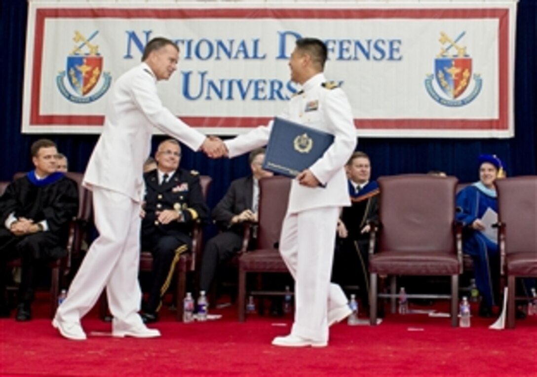 Navy Adm. James A. Winnefeld Jr., vice chairman of the Joint Chiefs of Staff, shakes hands with one of 645 graduates after delivering the commencement address for the National Defense University on Fort McNair in Washington, D.C., June 12, 2014. The university is a national security institution focused on advanced joint education, leader development and scholarship.