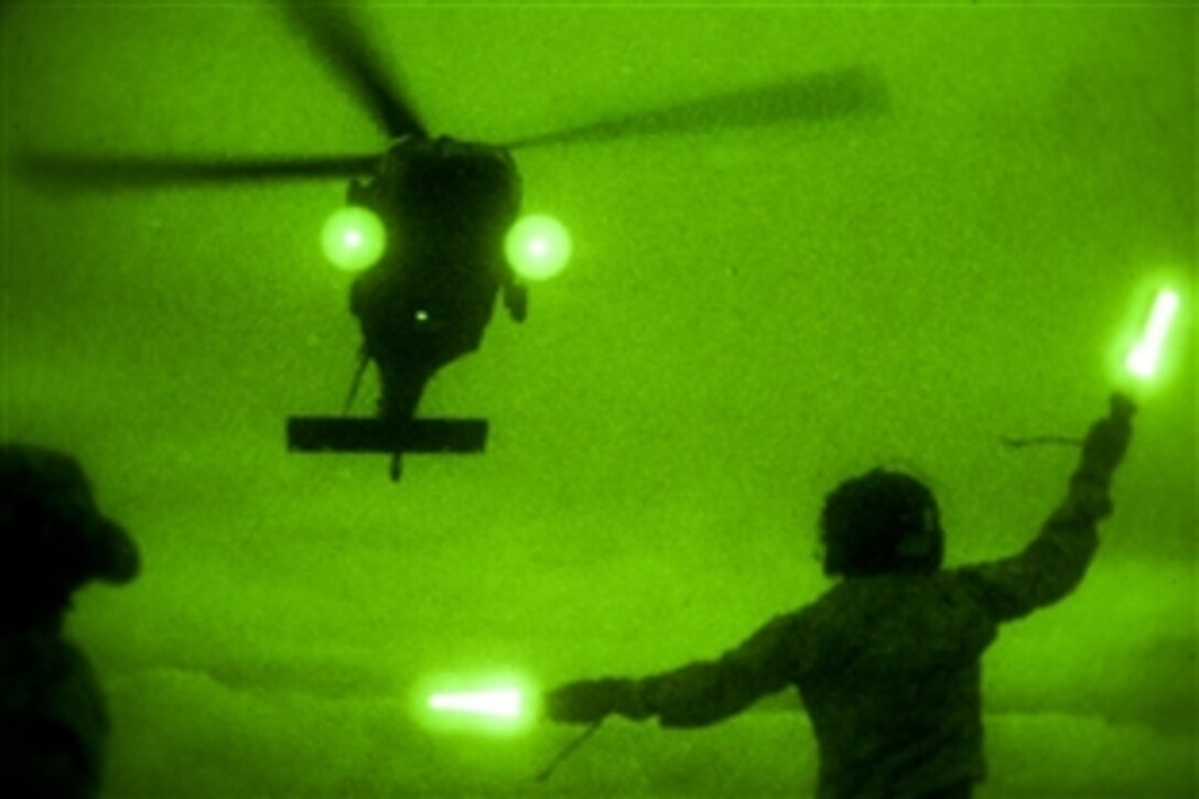 Army Sgt. 1st Class Louis Lawton guides a UH-60 Black Hawk helicopter to the landing zone during slingload training on Camp Johnson in Colchester, Vt., June 5, 2014. Lawton is assigned to the Massachusetts Army National Guard's Company C, 3rd Battalion, 126th Aviation Regiment.  