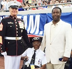 The Senior Enlisted Adviser to the Chairman of the Joint Chiefs of Staff, Marine Corps Sgt. Maj. Bryan B. Battaglia, left, alongside former World War II Army Pfc. Samuel Muldrew, 91, and Jacksonville Mayor Alvin Brown on the sidelines of EverBank Field in Jacksonville, Fla., during the USA and Nigeria teams’ soccer match, June 7, 2014.