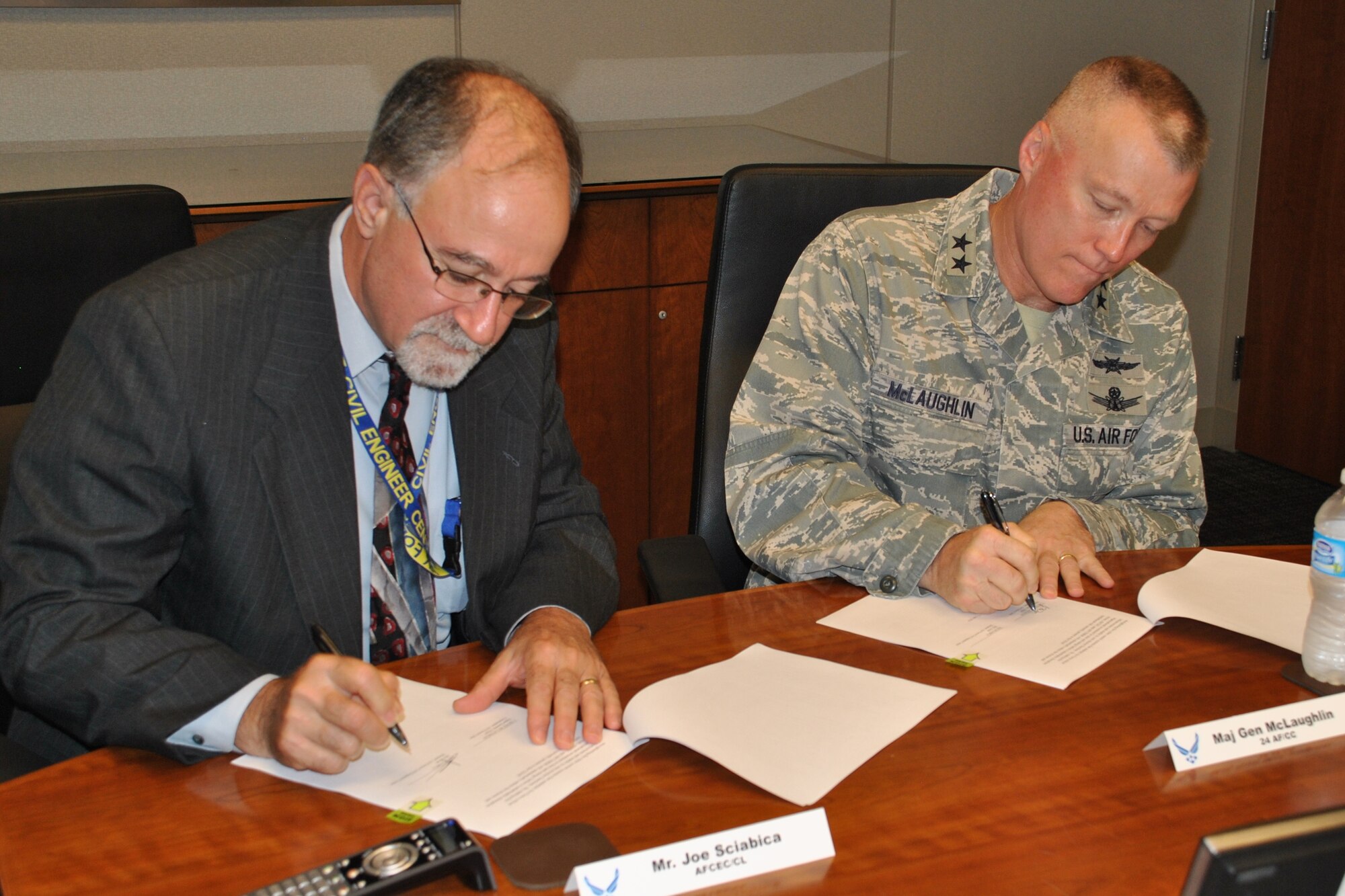 Joe Sciabica and Maj. Gen. J. Kevin McLaughlin sign the Air Force Civil Engineer Center-Air Forces Cyber nexus collaboration during a meeting June 12, 2014 at Joint Base San Antonio-Lackland, Texas. The initiative is designed to increase collaboration between the agencies in order to enhance the security of industrial control systems supporting critical Air Force infrastructures around the world. Sciabica is the AFCEC director and McLaughlin is the 24th Air Force and AFCYBER commander. (U.S. Air Force photo/Shannon Carabajal)