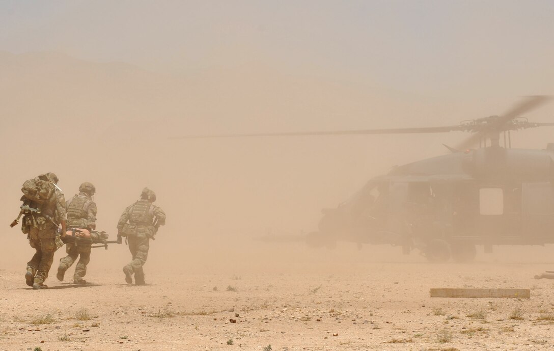 Pararescuemen assigned to the 306th Rescue Squadron quickly take a patient on a stokes litter to an awaiting HH-60G Pave Hawk helicopter assigned to the 305th RQS during a mass casualty training evolution June 6, 2014, at Davis-Monthan Air Force Base, Ariz. The mass casualty drill took place during the 943rd Rescue Group’s June unit training assembly weekend. (U.S. Air Force Photo/Master Sgt. Luke Johnson)