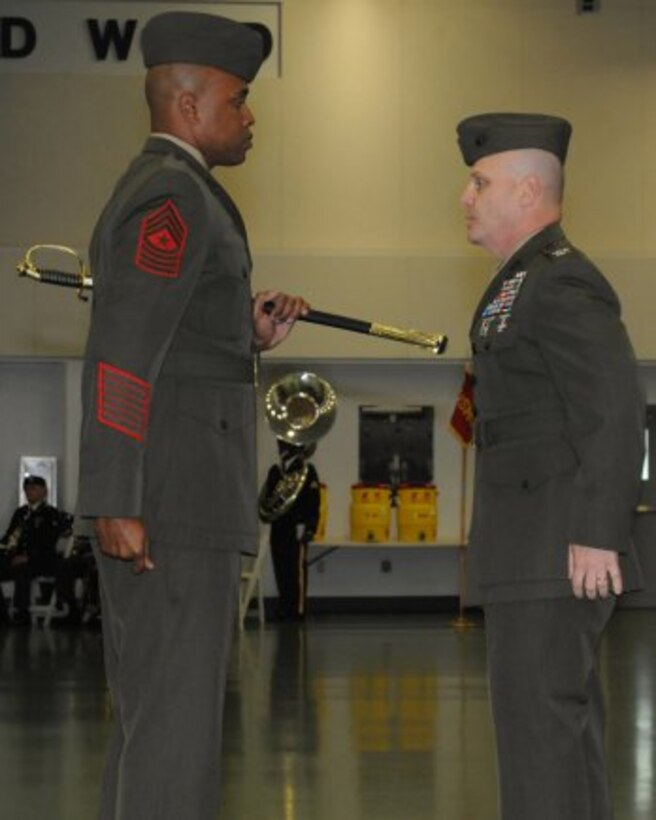 Marine Sgt. Maj. Jason Patrick, left, incoming Marine Detachment sergeant major, receives the NCO saber from Marine Col. John Giltz, detachment commander, symbolizing his assuming responsibilities as the new detachment sergeant major during a Post and Relief Ceremony Friday held in Nutter Field House.