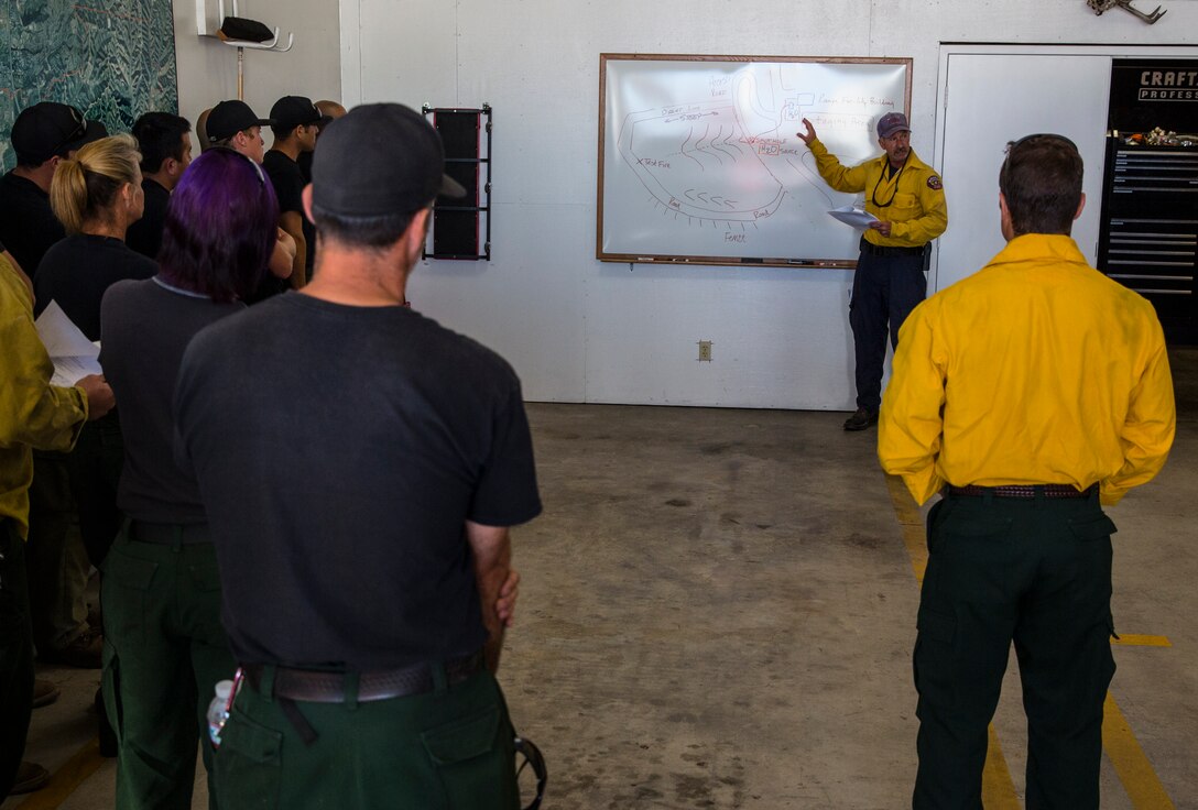 Paul Tompkins, operations chief with the Miramar Fire Department and range incident commander for this prescribed burn, conducts a brief before a prescribed burn aboard Marine Corps Air Station Miramar, Calif., June 12. The burns were held to prevent wildfires on an explosive ordnance disposal range aboard the air station.