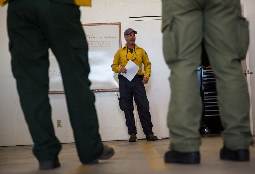 Paul Tompkins operations chief with the Miramar Fire Department and range incident commander for this prescribed burn, conducts a brief before a prescribed burn aboard Marine Corps Air Station Miramar, Calif., June 12. The burns were held to prevent wildfires on an explosive ordnance disposal range aboard the air station.