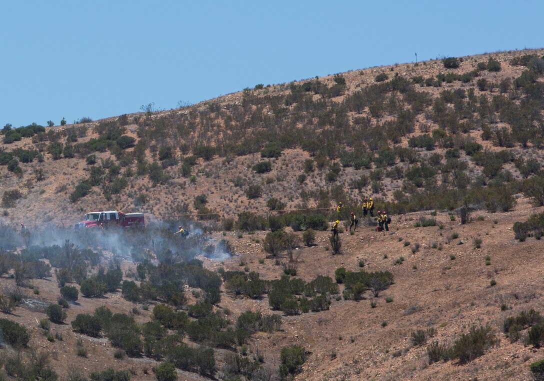 Firefighters with the Miramar Fire Department and the Laguna Hotshots work together during a prescribed burn aboard Marine Corps Air Station Miramar, Calif., June 12. The Miramar Fire Department conducts these burns to reduce the risk of wildfires.