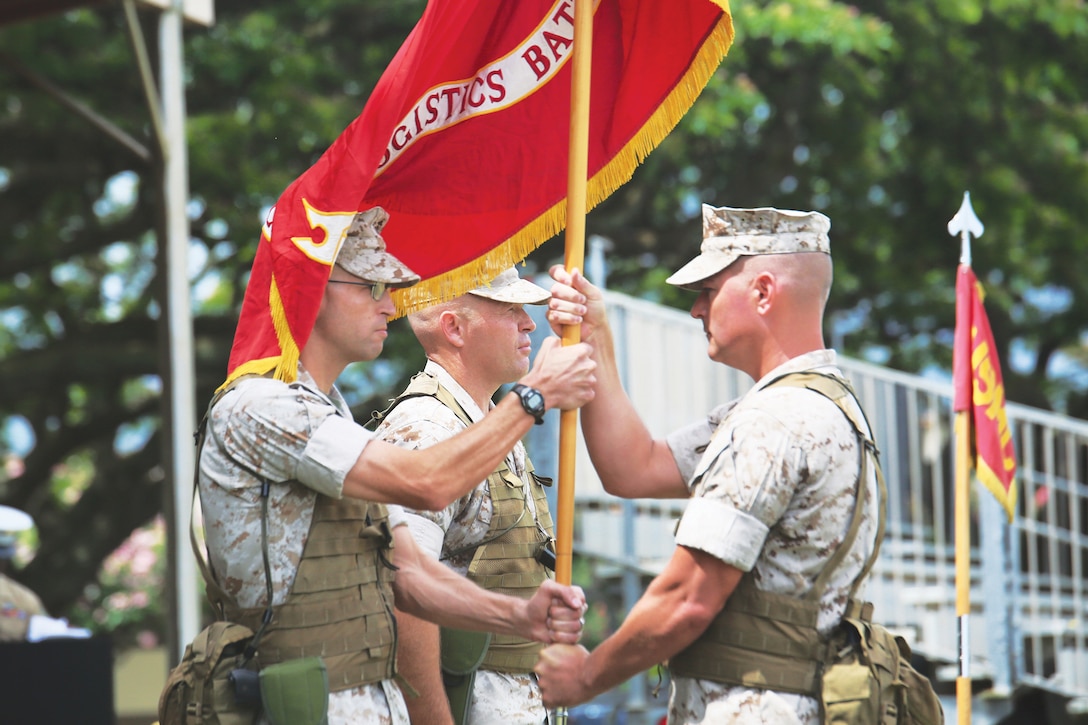 Lt. Col. Justin R. Reiman, outgoing commanding officer, Combat Logistics Battalion 3, 3rd Marine Logistics Group, receives the battalion colors from Sgt. Maj. James D. Vealey, CLB-3 sergeant major before handing them off to Lt. Col. Patrick M. Tucker, incoming commanding officer of CLB-3, June 12, 2014, at a change of command ceremony at Dewey Square. (U.S. Marine Corps photo by Cpl. Nathan Knapke)