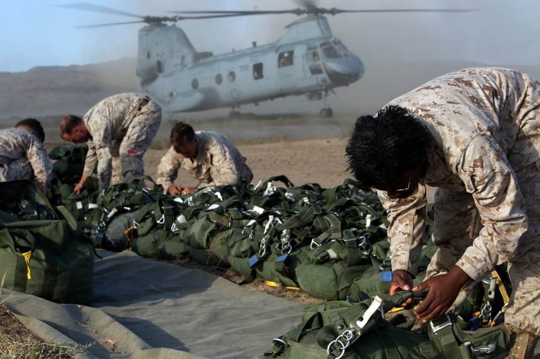 Lance Cpl. Madison J. Kronberger, 18, from Dothan, AL (right) gets her gear ready for a static line jump out of a CH-46 Sea Knight aboard Camp Pendleton, California, June 5, 2014. The Marines conducted two day jumps and two night jumps at approximately 1,500 feet.  Three Marines jumped with full combat gear in order to complete the requirements for their parachutist insignia.