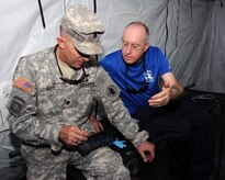 U. S. Army Lt. Col. Michael Alvis, MEDEL deputy commander, browses through a Global MedAid real-time report which tells him how many patients have been treated.  In preparation for the 2014 hurricane season, the Joint Task Force-Bravo Medical Element (MEDEL) conducted a humanitarian assistance/disaster response (HA/DR) exercise at Soto Cano Air Base, Honduras June 12, 2014.  The MEDEL's mission was to establish a forward medical treatment operation capable of providing triage, primary care, surgical capabilities, patient holding and evacuation.  As part of this exercise, a suite of mobile technology applications that run on smartphones and tablets were used to enhance the capabilities of the unit: Global MedAid, Medical Application of Speech Translation (MAST) and GeoSHAPE.  (Photo by U. S. Air National Guard Capt. Steven Stubbs)