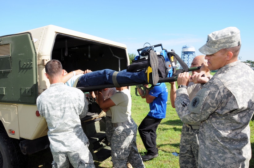 Members of the Medical Element load a hurricane victim in an ambulance for a ground medical evacuation to a hospital in Tegucigalpa, Honduras during a hurricane response exercise.  In preparation for the 2014 hurricane season, the Joint Task Force-Bravo Medical Element (MEDEL) conducted a humanitarian assistance/disaster response (HA/DR) exercise at Soto Cano Air Base, Honduras June 12, 2014.  The MEDEL's mission was to establish a forward medical treatment operation capable of providing triage, primary care, surgical capabilities, patient holding and evacuation.  As part of this exercise, a suite of mobile technology applications that run on smartphones and tablets were used to enhance the capabilities of the unit: Global MedAid, Medical Application of Speech Translation (MAST) and GeoSHAPE.  (Photo by U. S. Air National Guard Capt. Steven Stubbs)