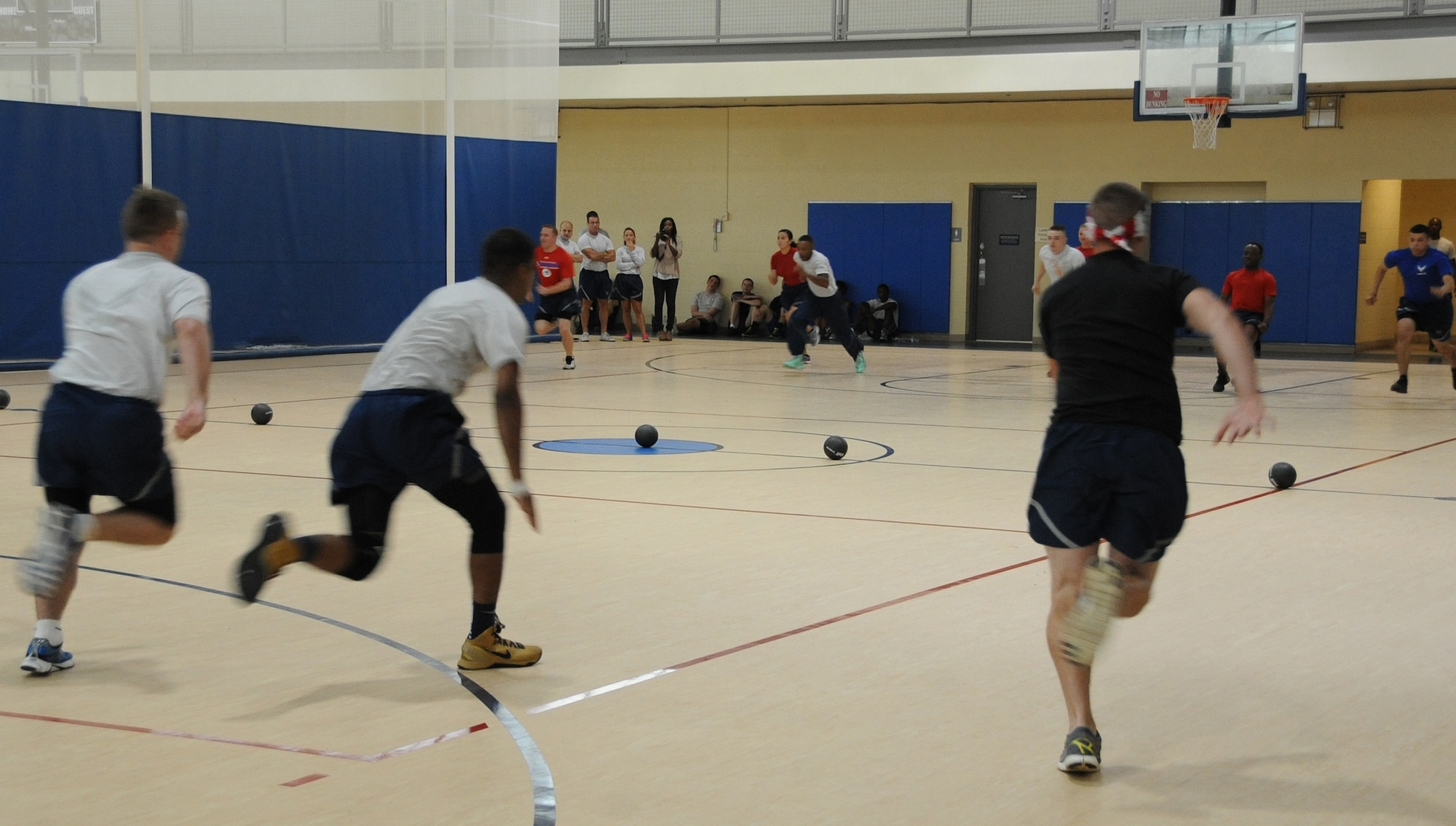 Barksdale Airmen sprint to a row of balls during a dodgeball competition as part of Sports Day at Barksdale Air Force Base, La., June 13, 2014. Sports Day is an annual event that gives Airmen the opportunity to participate in several individual and team sports to boost morale and camaraderie. (U.S. Air Force photo/Senior Airman Benjamin Gonsier)