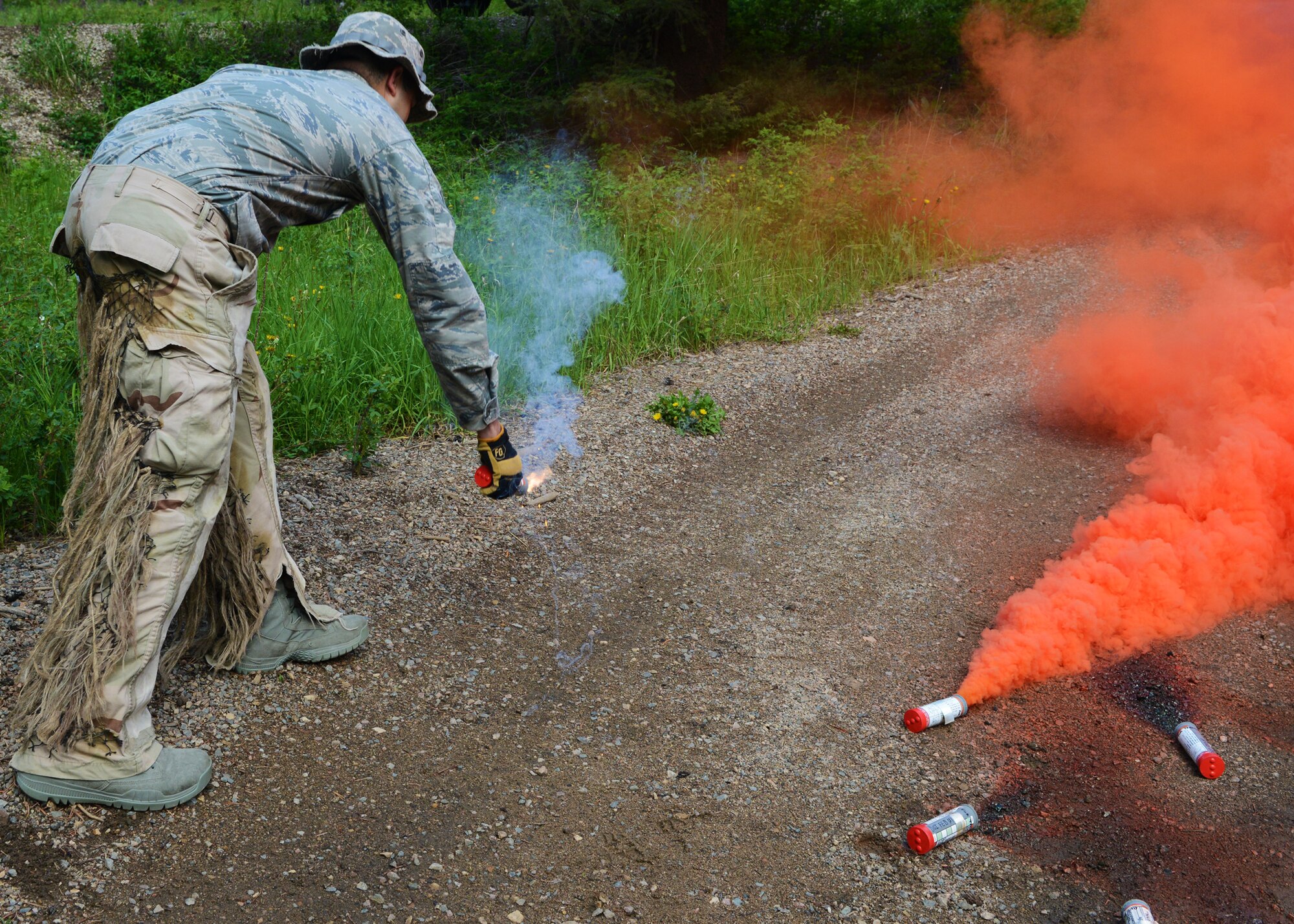 Senior Airman Matthew Dubon, 341st Security Forces Group Tactical Response Force Nuclear Advanced Designated Marksman, tosses a flare during a survival, evasion, resistance and escape field training exercise in Monarch, Mont., on June 11. Dubon and two NATMs from the 341st SFG, as well as 40th Helicopter Squadron aircrew members learned navigational, basic survival, evasion and escape skills during the FTX. (U.S. Air Force photo/Senior Airman Katrina Heikkinen)
