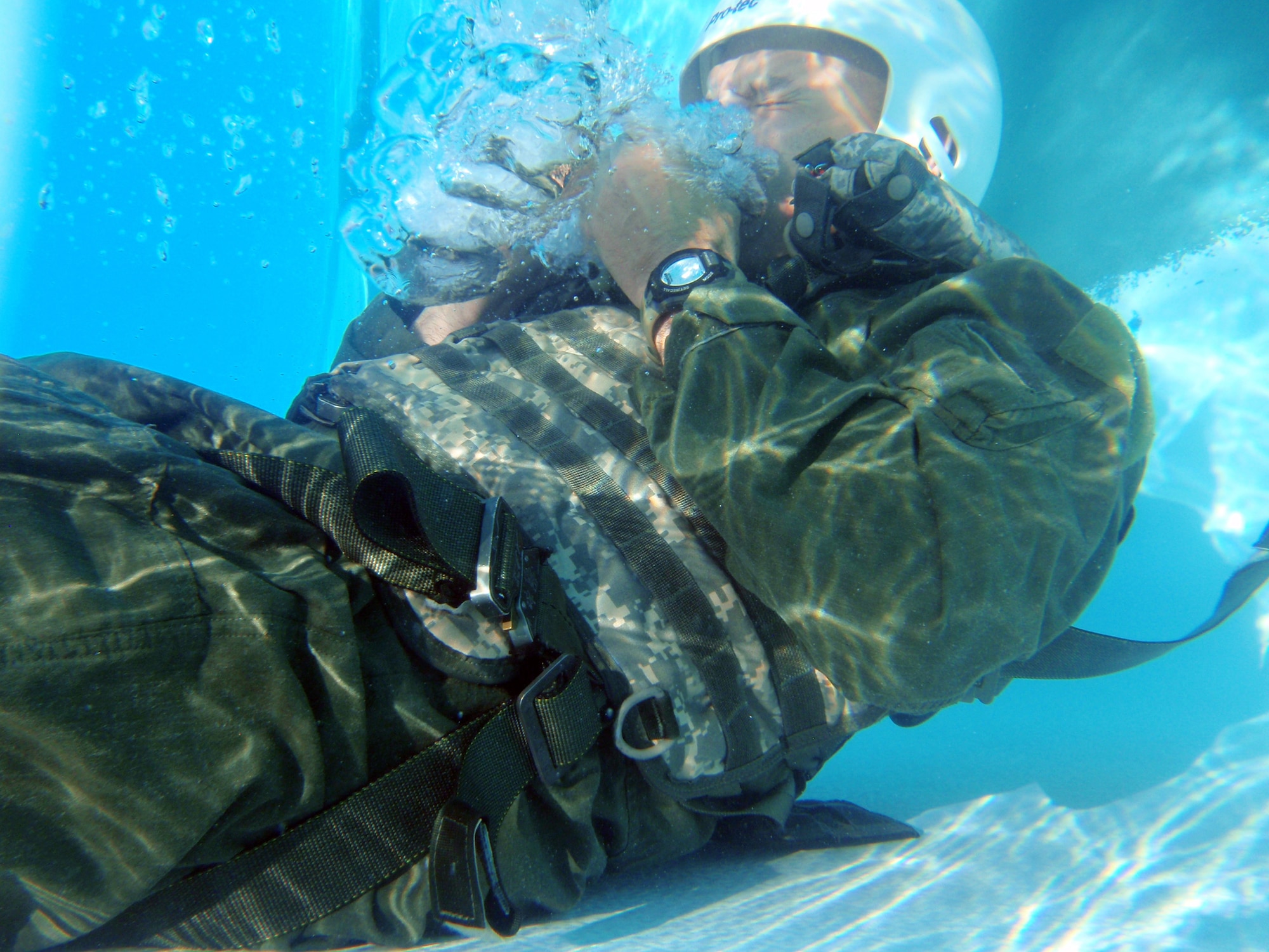 Lt. Col. Thomas Higgins, 40th Helicopter Squadron director of staff, experiences water going up his nose as he breathes into a C-bottle during water survival skills training at the Malmstrom Air Force Base pool on June 10. Members of the 40th HS endured survival, evasion, resistance and escape training June 9 to 13. (U.S. Air Force photo/Senior Airman Katrina Heikkinen)