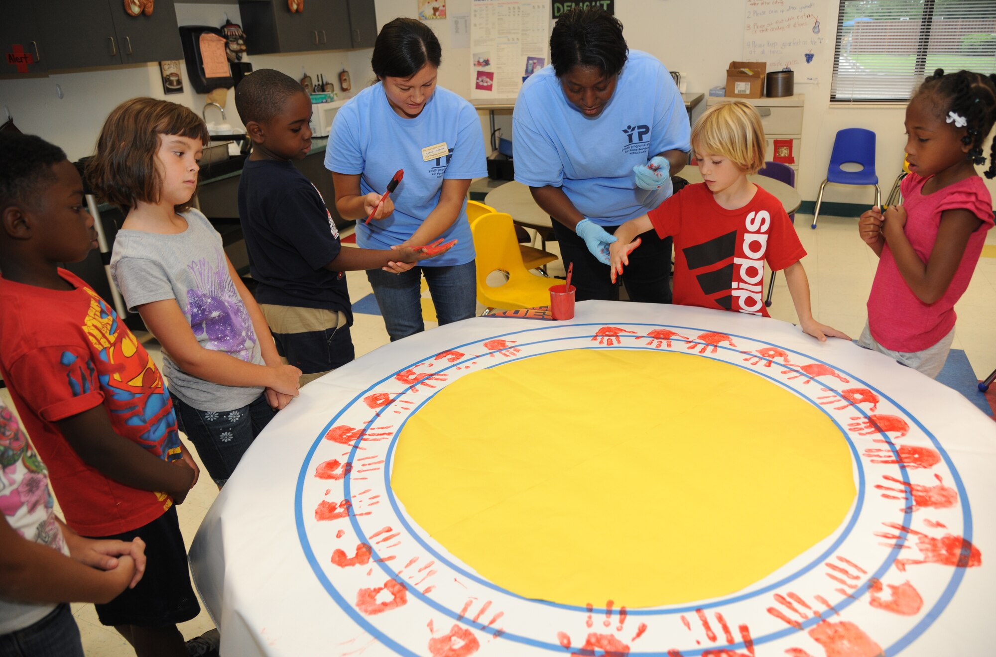 Children at the Keesler Youth Center decorate a banner with their handprints June 13, 2014, at the Youth Center, Keesler Air Force Base, Miss.  The banner will be presented to the Armed Forces Retirement Home on behalf of the Ringling Brothers Circus.  (U.S. Air Force photo by Kemberly Groue)