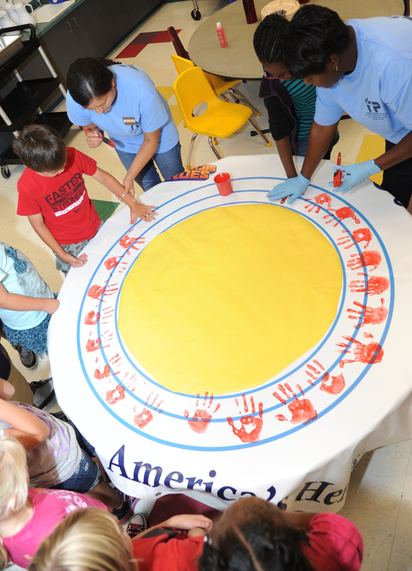 Children at the Keesler Youth Center decorate a banner with their handprints June 13, 2014, at the Youth Center, Keesler Air Force Base, Miss.  The banner will be presented to the Armed Forces Retirement Home on behalf of the Ringling Brothers Circus.  (U.S. Air Force photo by Kemberly Groue)