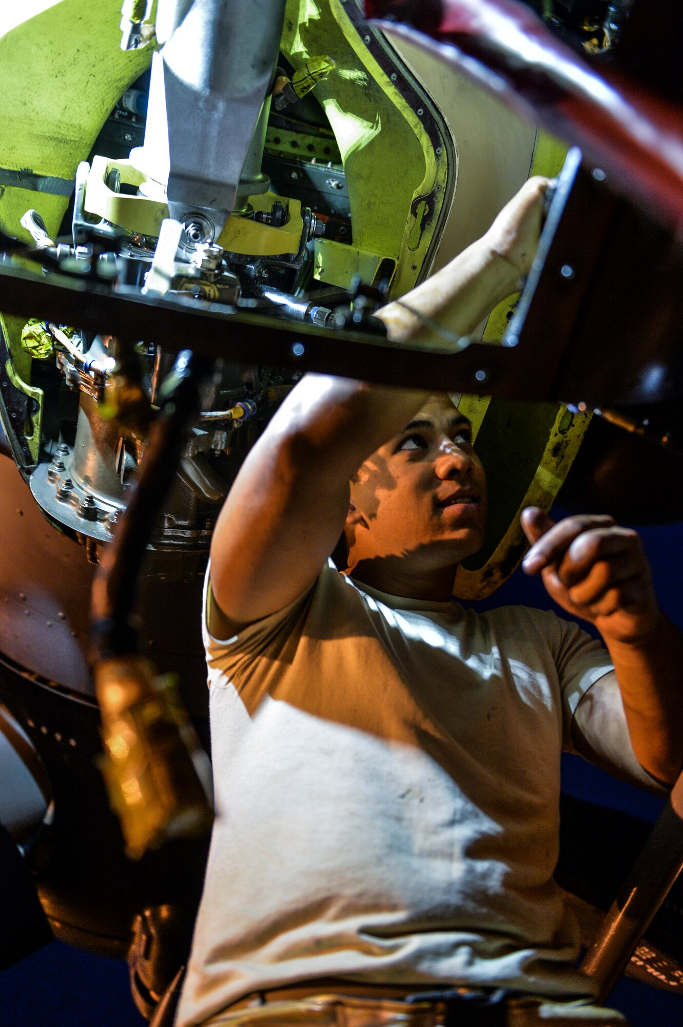 Senior Airman Chris Abadia, 801st Special Operations Aircraft Maintenance Squadron dedicated crew chief, removes screws from a CV-22 Osprey on Hurlburt Field, Fla., June 13, 2014. (U.S. Air Force photo/Senior Airman Christopher Callaway)