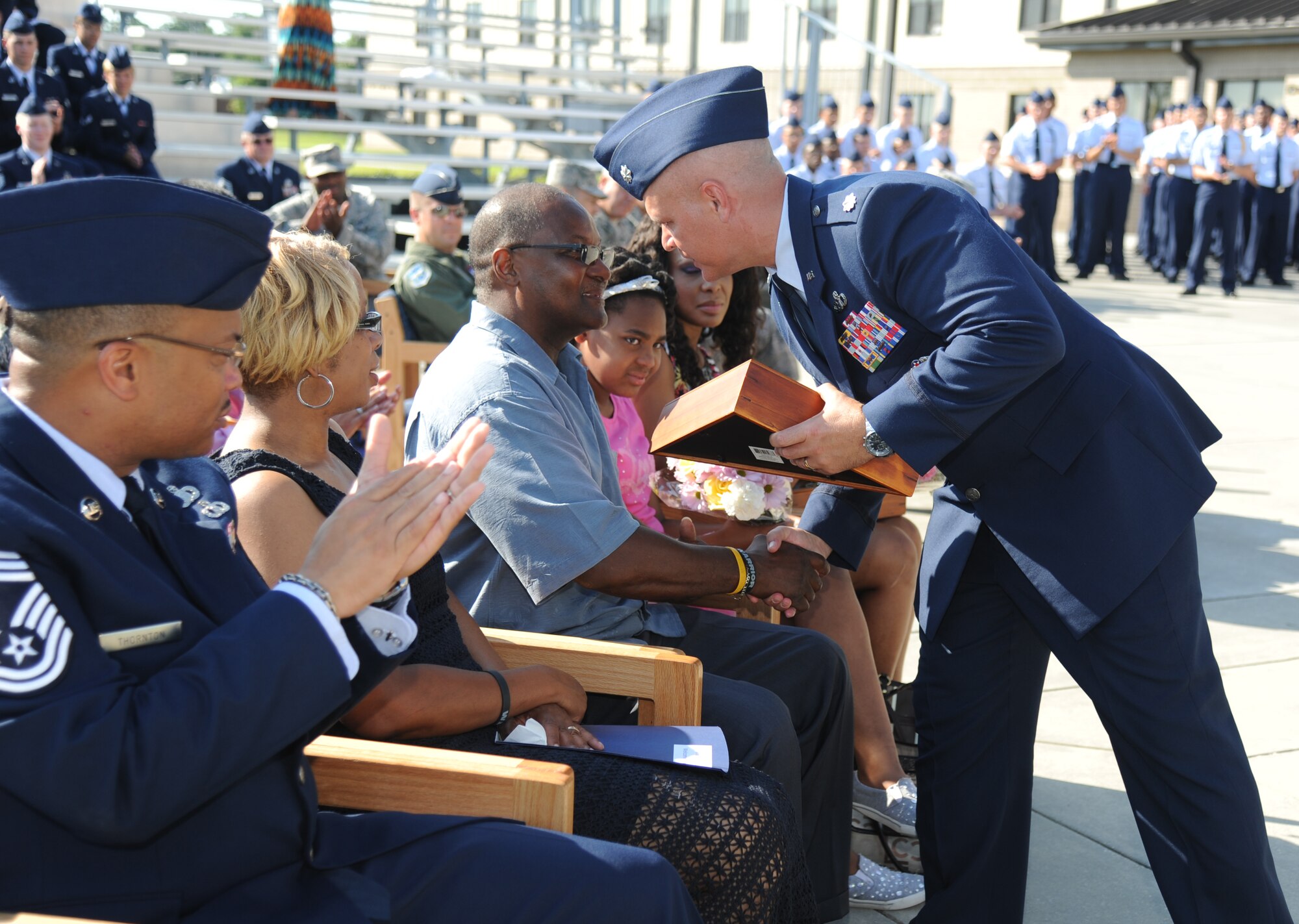 Lt. Col. Kevin Bray, 334th Training Squadron commander, presents a memento to Michael Holt, the father of the late Airman 1st Class Antoine Holt, during a re-dedication ceremony June 12, 2014, in front of Avery Manor at Keesler Air Force Base, Miss.  Airman Holt, a former student in the 334th TRS, lost his life April 10, 2004 while at Balad Air Base, Iraq, when his tent was hit by a mortar attack. (U.S. Air Force photo by Kemberly Groue)