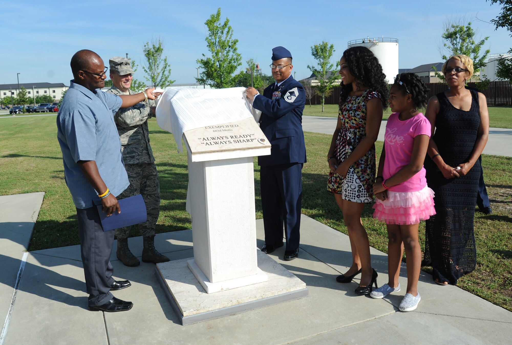 Brig. Gen. Patrick Higby, 81st Training Wing commander, assists family and friends of the late Airman 1st Class Antoine Holt with unveiling a memorial honoring Holt June 12, 2014, in front of Avery Manor at Keesler Air Force Base, Miss.  Holt, a former student in the 334th Training Squadron, lost his life April 10, 2004 while at Balad Air Base, Iraq, when his tent was hit by a mortar attack.  (U.S. Air Force photo by Kemberly Groue)