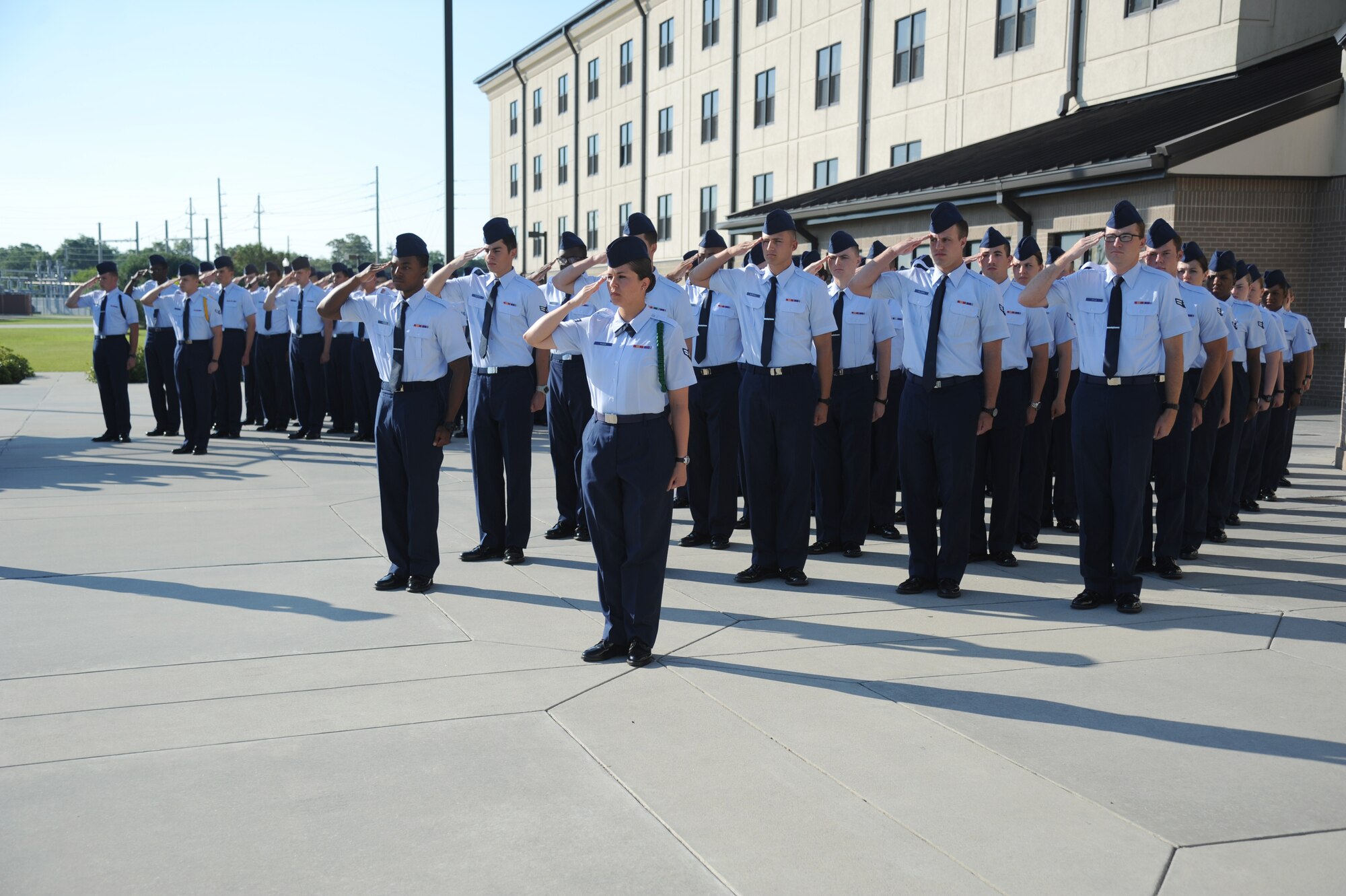 Airmen in the 334th Training Squadron, render a salute while the National Anthem was sung during a re-dedication ceremony honoring the late Airman 1st Class Antoine Holt June 12, 2014, in front of Avery Manor at Keesler Air Force Base, Miss.  Holt, a former student in the 334th TRS, lost his life April 10, 2004 while at Balad Air Base, Iraq, when his tent was hit by a mortar attack.  (U.S. Air Force photo by Kemberly Groue)