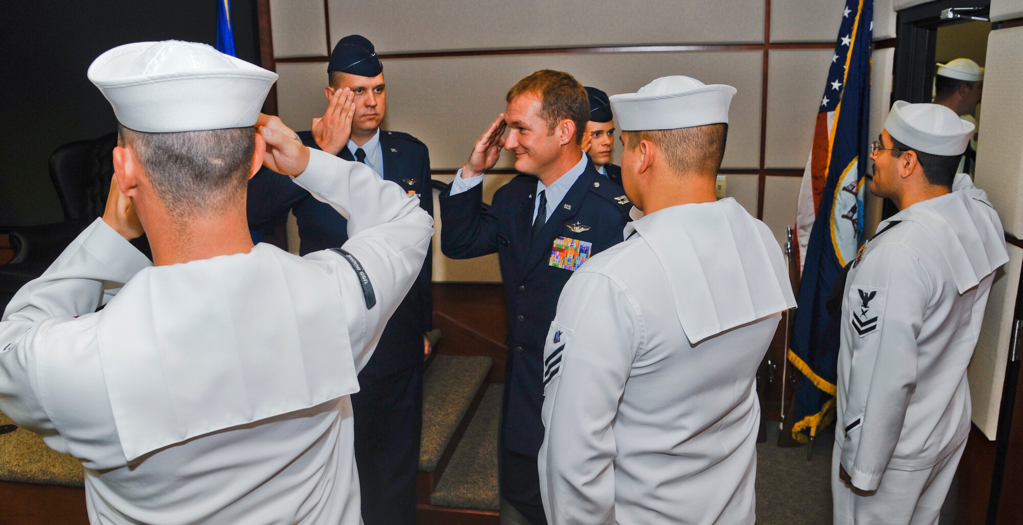 U.S. Navy Honor Guard from the Navy Operational Support Center and Airmen render salutes to Capt. Jason Scoggins, 22nd Air Refueling Squadron navigator, at his retirement ceremony June 12, 2014, at McConnell Air Force Base, Kan. Their formation was part of a Navy tradition, ‘piping on the side’ as the official party arrives. (U.S. Air Force photo/Airman 1st Class John Linzmeier)