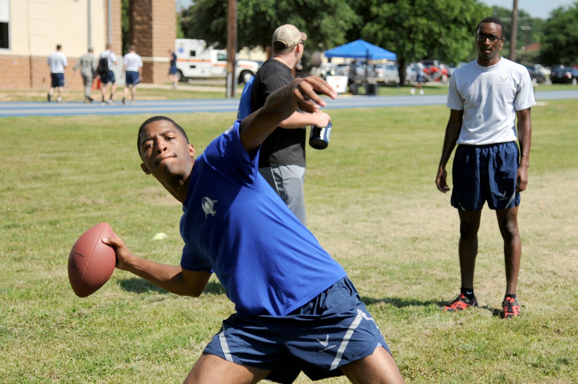 Senior Airman Austyn Mason, 20th Bomb Squadron, demonstrates his quarterback skills during the Sports Day competition at Barksdale Air Force Base, La., June 13, 2014. Sports Day consisted of various team events including dodgeball, tug-of-war, soccer, volleyball, and basketball. Sports Day was designed to improve teamwork and help increase the awareness of fitness, sports programs and boost morale. (U.S. Air Force photo/Tech. Sgt. Marie Brown)