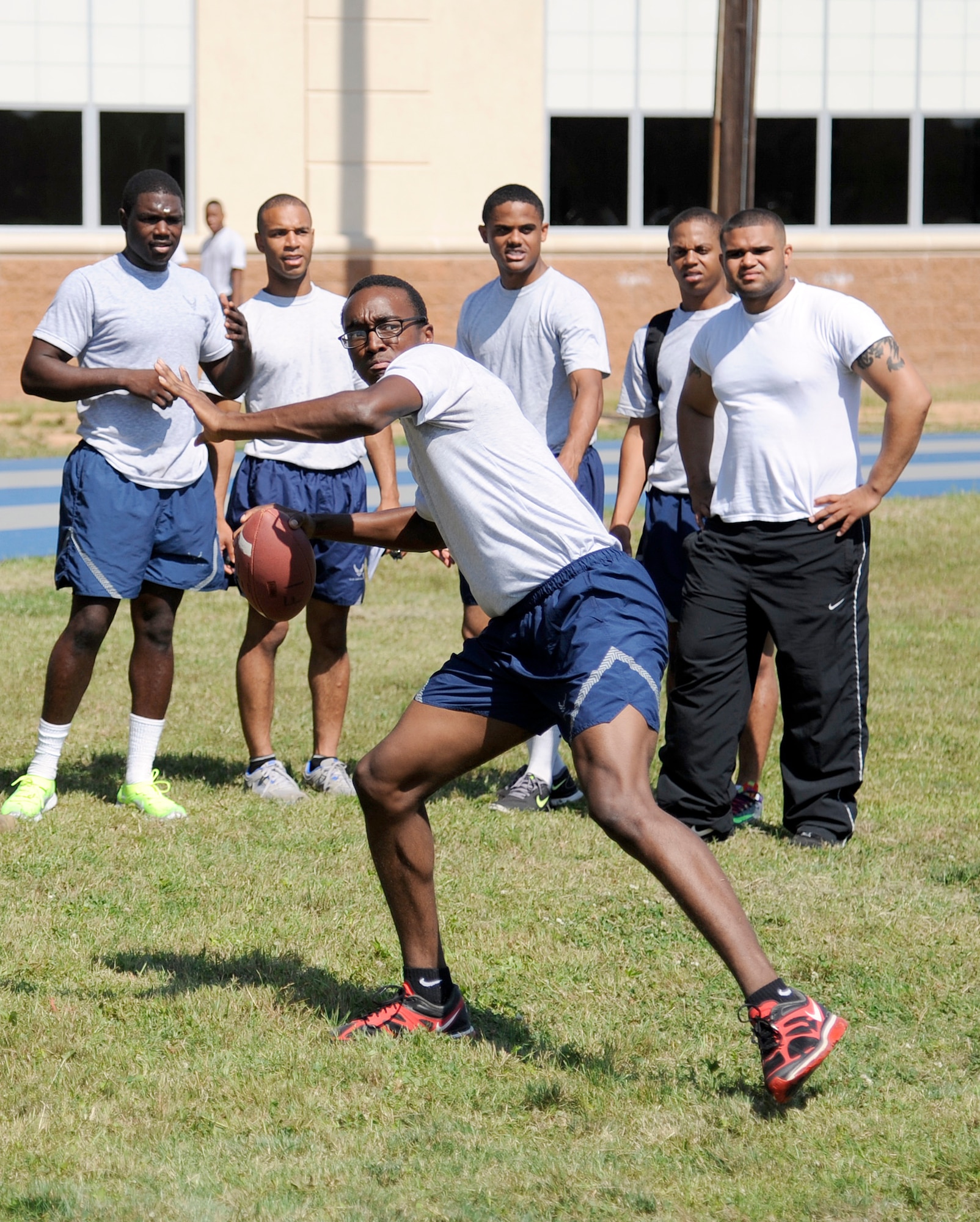 Airman 1st Class Isaac Watson, 2nd Aircraft Maintenance Squadron, prepares to throw a football during the Quarterback Skills competition as part of Sports Day at Barksdale Air Force Base, La., June 13, 2014. Watson snatched the first place spot for 2nd AMXS for having the overall  farthest throw with the 26th Operational Weather Squadron coming in second and the 20th Bomb Squadron taking third. (U.S. Air Force photo/Tech. Sgt. Marie Brown)