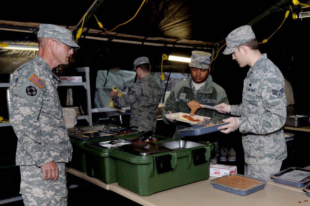 Services Airmen from the 28th Force Support Squadron serve breakfast to South Dakota National Guardsmen at Camp Lancer at Ellsworth Air Force Base, S.D., June 11, 2014. Ellsworth Airmen served meals daily to more than 700 servicemembers throughout the month of June in support of the SDNG Golden Coyote exercise. (U.S. Air Force photo my Airman 1st Class Rebecca Imwalle/Released)