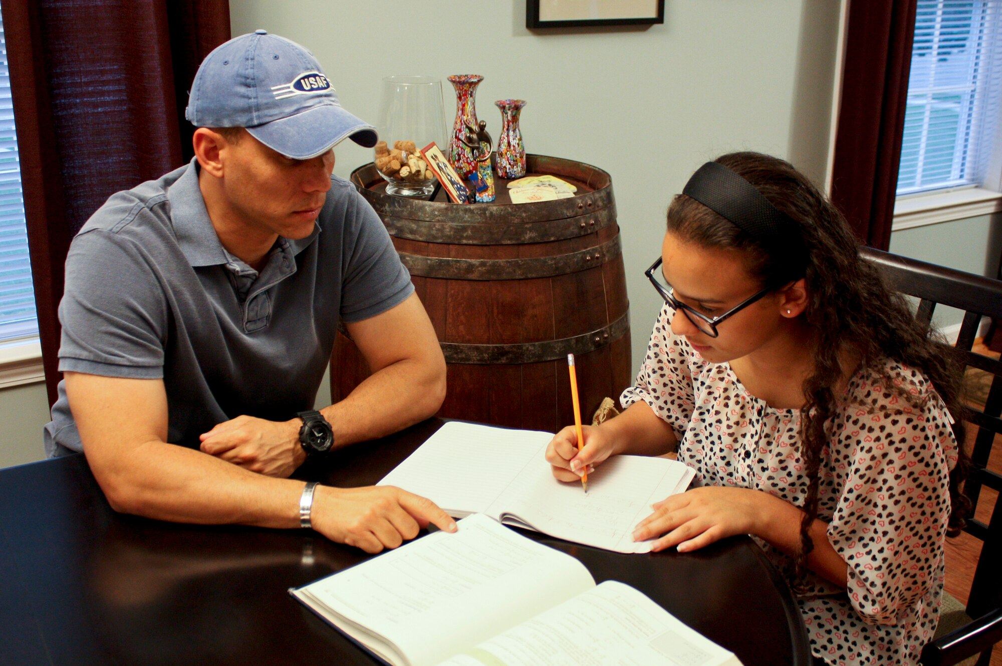 Maj. Nelson Avilesfigueroa, 4th Communications Squadron commander, helps Carla Aviles-Jimenez, his daughter, with her homework recently at their residence in Goldsboro, North Carolina. Aviles-Jimenez was awarded the $50,000 Corvias Foundation Our Future Scholarship to be used at the university of her choice. The scholarship is awarded annually to dependents of service members assigned to installations where Corvias Military Living provides housing. (U.S. Air Force photo/Airman 1st Class Aaron J. Jenne)