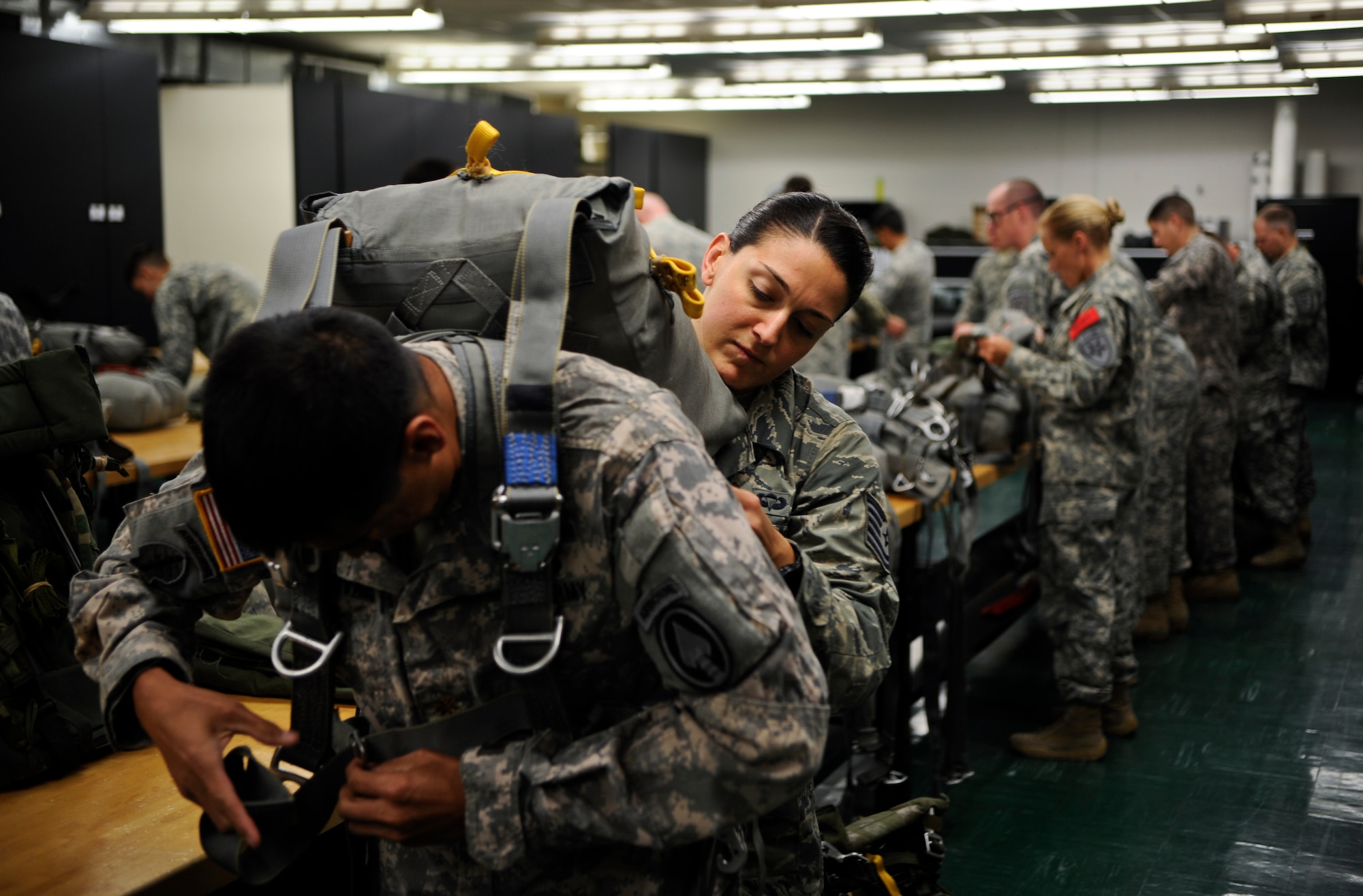 Tech. Sgt. Veronica Gatta, Joint Communications Support Element Direct Communications Support team chief, assists Maj. Jon Narvaes, Special Operations Command branch chief, in gearing up May 21, 2014 at MacDill Air Force Base, Fla. This type of joint assignment is Gatta’s first in her career and has provided an extremely rare and motivating experience.  (U.S. Air Force photo by Senior Airman Vernon L. Fowler Jr./Released)