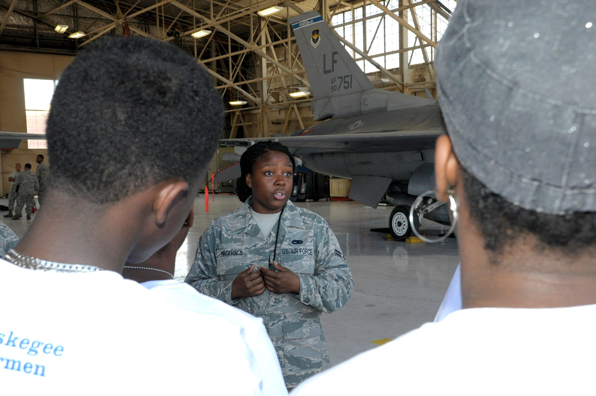 Airman 1st Class Ashley Nichols, 308th Aircraft Maintenance Unit F-16 crew chief, briefs students on her job and the aircraft she works on May 30 in Hangar 914 at Luke Air Force Base. The students toured the base as part of the Archer-Ragsdale Arizona Chapter of Tuskegee Airmen Inc. Aviation Career Education Camp. (U.S. Air Force photo/Staff Sgt. Timothy Boyer)