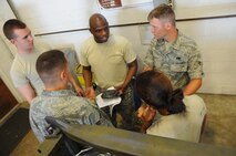 Tech Sgt. Torrey Byrd, center, 372nd Training Squadron Field Training Detachment 205 weapons instructor, explains operation of an A6 initiator on a cluster bomb rack at Barksdale Air Force Base, La., June 4, 2014. FTD has 16 instructors who teach new maintenance Airmen B-52H Stratofortress specifics. By providing training to maintenance personnel, senior leaders, and aircrew members, FTD helps ensure the mission of delivering devastating B-52 combat capability, anytime anywhere. (U.S. Air Force photo/Staff Sgt. Jason McCasland)
