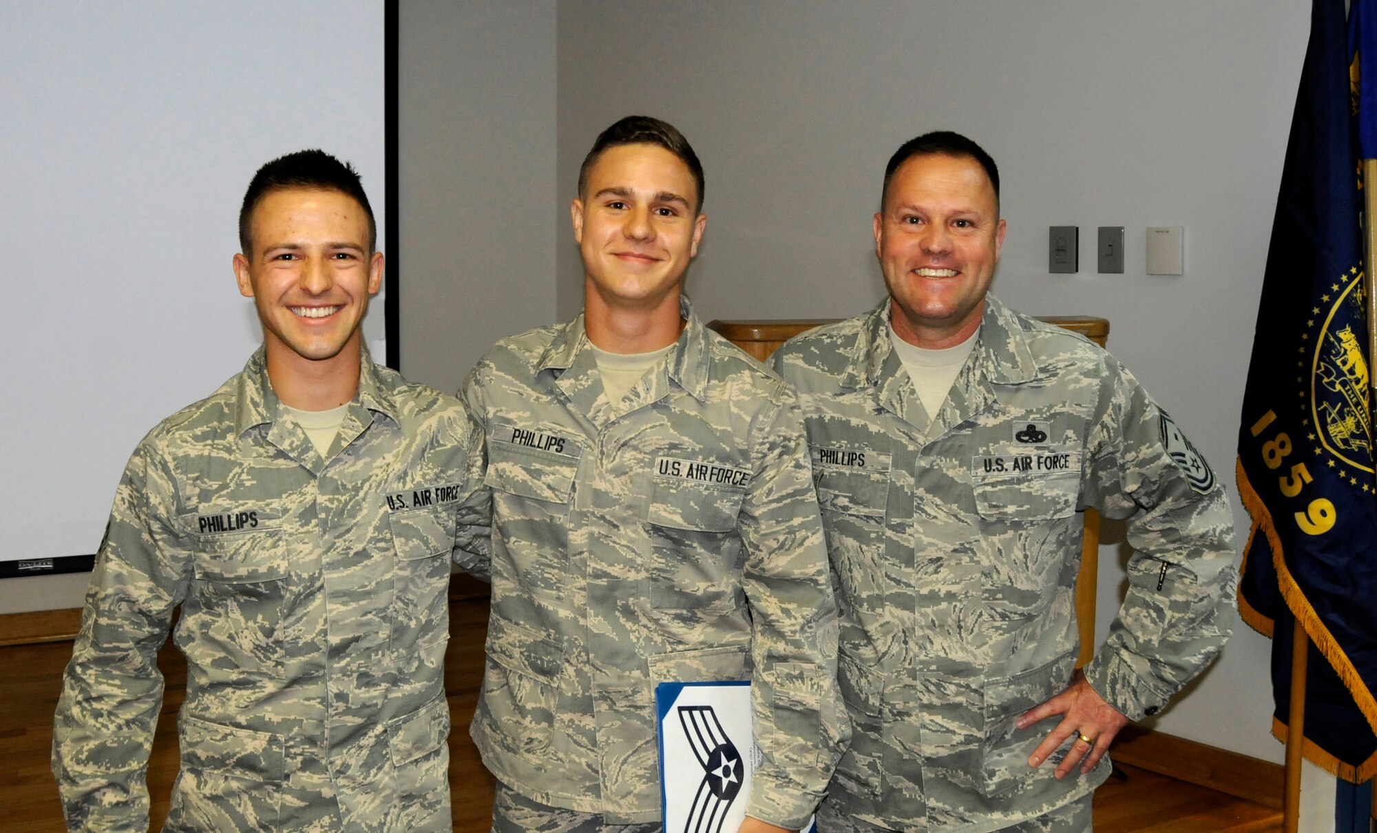 Airman 1st Class Zachary Phillips, fuel systems specialist for the 142nd Fighter Wing, center, was promoted to the rank of Senior Airman June 7, 2014 at a ceremony on the Portland Air National Guard Base, Ore. Senior Airman Lewis Phillips, left, Zachary Phillips' brother and Senior Master Sgt. John Phillips, his father, right, were in attendance and participated in the ceremony. (U.S. Air National Guard photo by 
Staff Sgt. Brandon Boyd, 142nd Fighter Wing Public Affairs/released)
