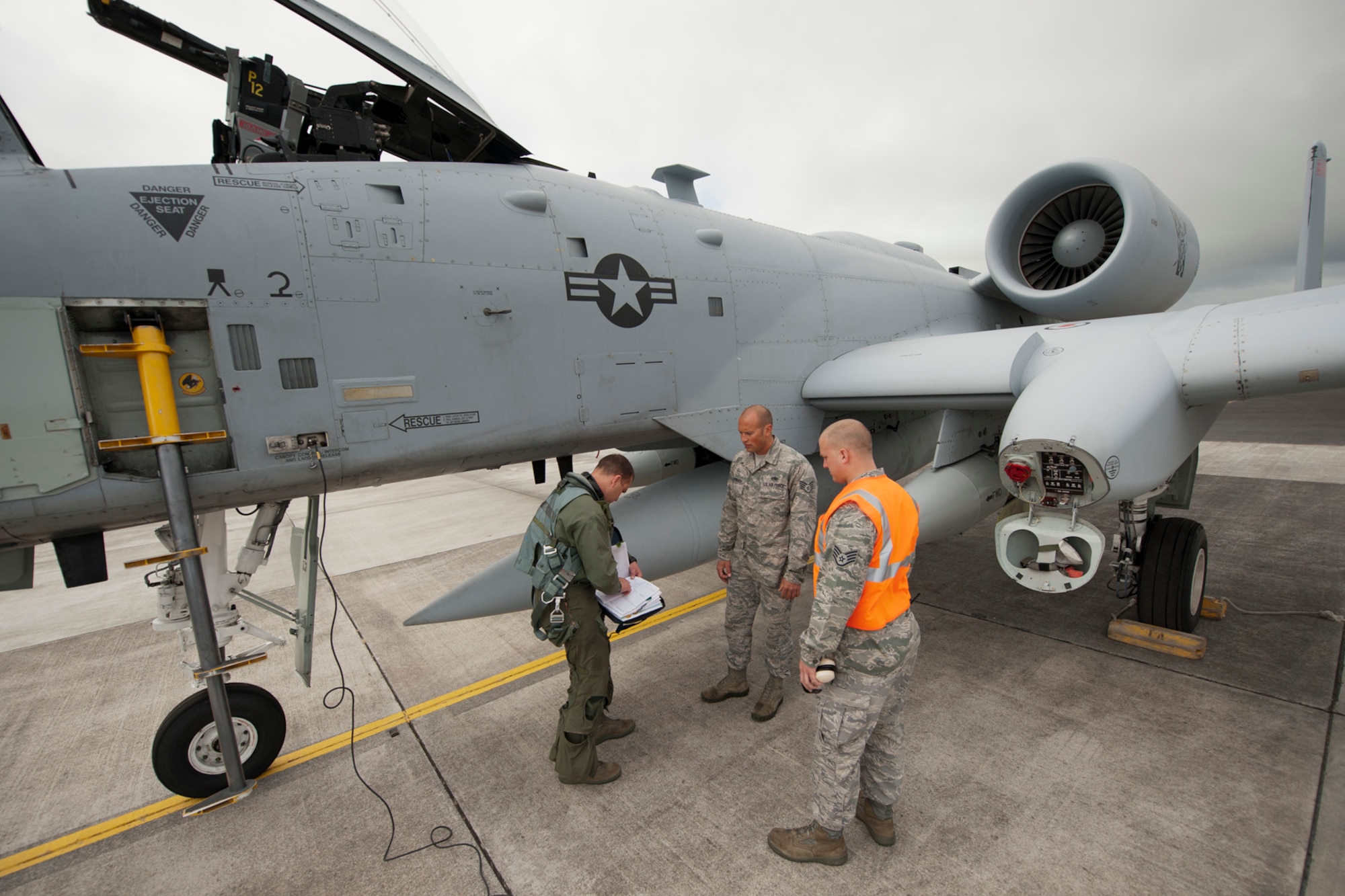 U.S. Air Force Capt. Ryan Brown, left, 190th Fighter Squadron A-10 Thunderbolt pilot, fills out a preflight log for Staff Sgt. Robert McDonough, center, 65th Operations Support Squadron A-10 crew chief, and Staff Sgt. Tanner Schuman, 65th OSS aerospace ground equipment technician, June 10, 2014, Lajes Field, Azores, Portugal.  The A-10 is specifically designed for close air support, and is capable of large and varied ordnance load, long loiter time, accurate weapons delivery, austere field capability and survivability. (U.S. Air Force photo by Tech. Sgt. Paul Villanueva II/Released)