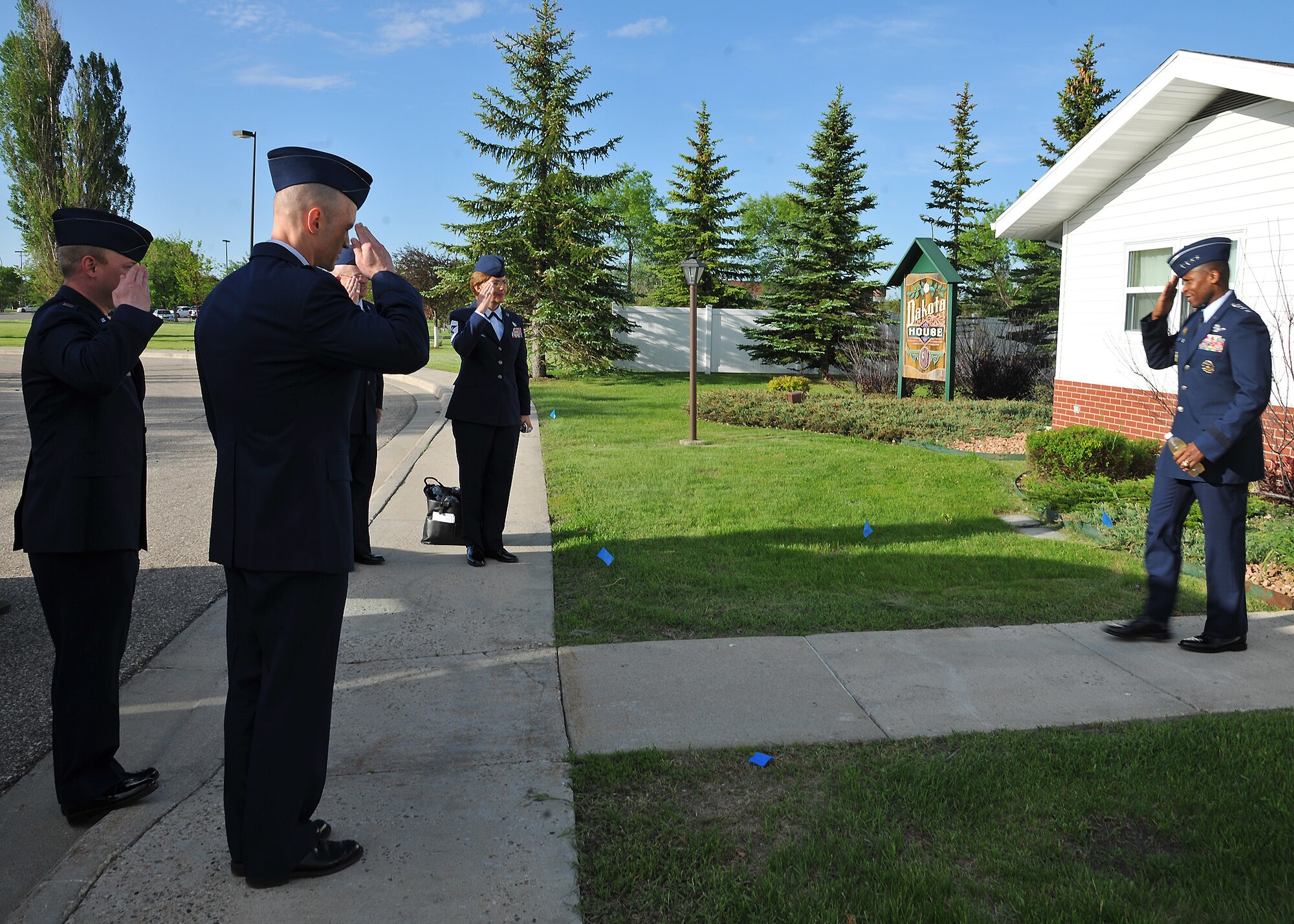 Gen. Darren McDew, Commander of Air Mobility Command, smiles and returns a salute to a group of Warriors of the North, who stood steadfast to greet him with a morning salute as he walked out of the North Dakota House in order to address approximately 1,500 civilians and service members during an all call at Grand Forks Air Force Base, North Dakota, June 10, 2014. Less than 30 minutes later the four-star general delivered what some people described as one of the most engaging and practical-minded formal addresses they’d ever heard from general officers. The all call was part of the general’s official visit to the base. (U.S. Air Force photo/Senior Airman Xavier Navarro)