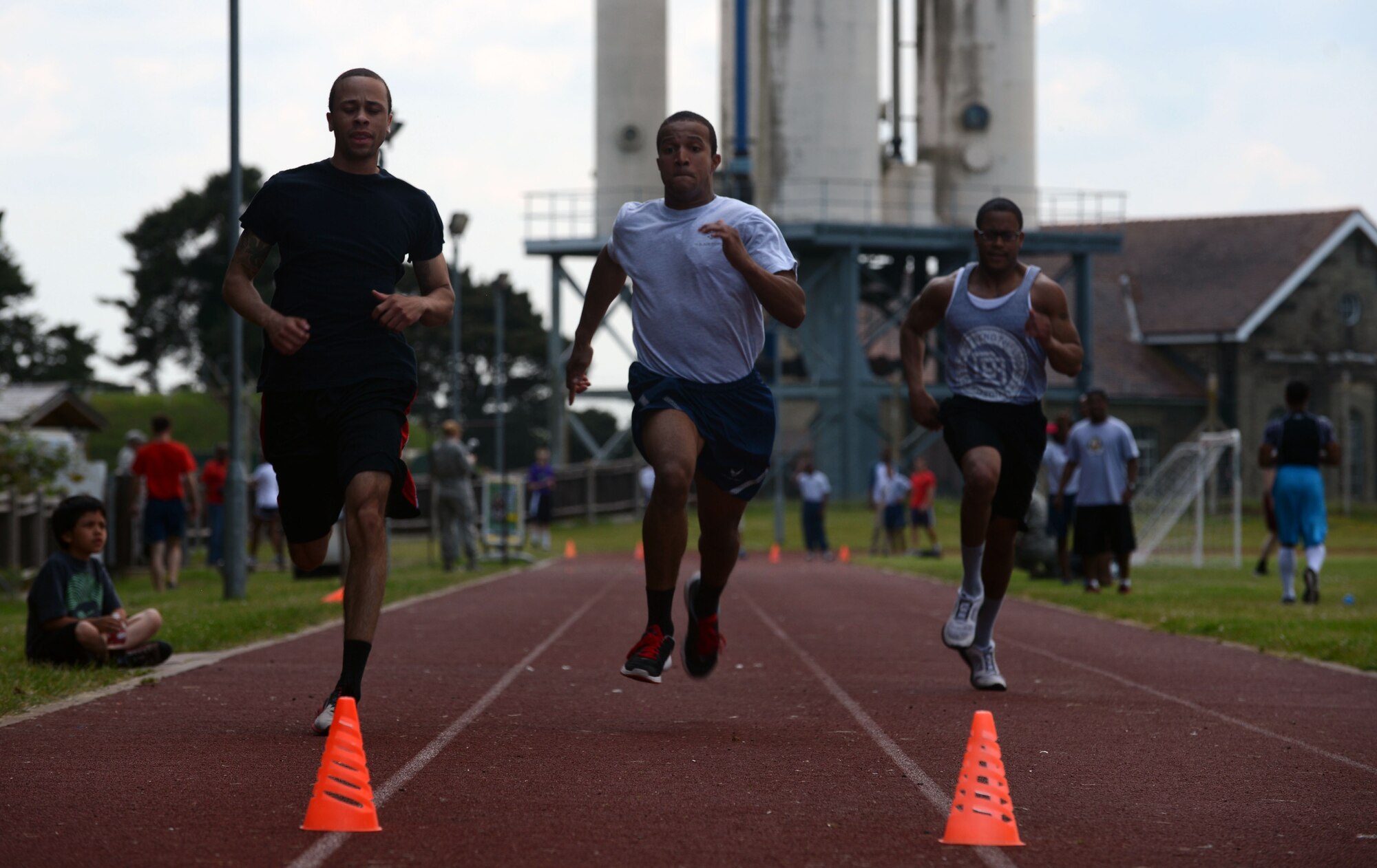 Team Mildenhall members race to the finish line of a 100-meter dash June 13, 2014, at Heritage Park on RAF Mildenhall, England. The dash was one of many events which made up the Marauder Melee, an annual competition between various units on base. (U.S. Air Force photo/Airman 1st Class Preston Webb/Released)