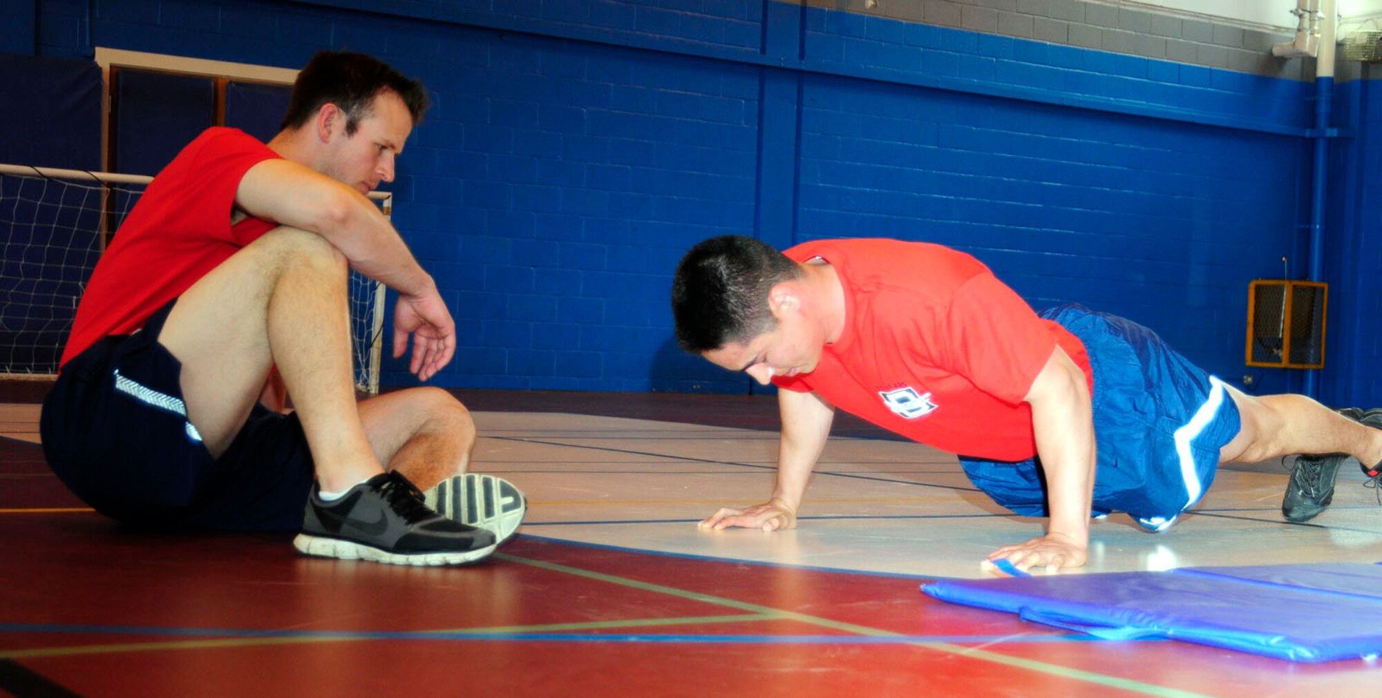U.S. Air Force 1st Lt. Matthew Kellogg, 351st Air Refueling Squadron pilot from Okinawa, Japan, speeds through push-ups as U.S. Air Force Capt. Zack Ziegler, 351st ARS executive officer from Seagrove, N.C., counts Kellogg’s push-ups during the Mad Marauder Fitness Challenge, one of the Marauder Melee June 13, 2014, on RAF Mildenhall, England. The Marauder Melee is an annual sports day promoting espirit de corps amongst units on base. Kellogg knocked out 105 push-ups in 1 minute. (U.S. Air Force photo/Karen Abeyasekere/Released)