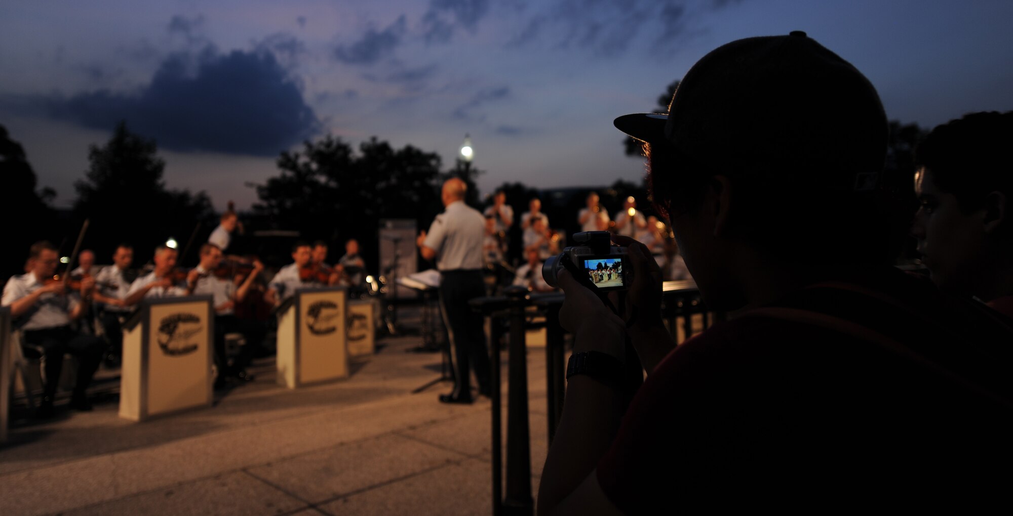 An audience member at the D-Day 70th Anniversary Big Band Salute concert captures a photo of The United States Air Force Band’s performance on the west side steps of the U.S. Capitol Building, Washington, D.C., June 10, 2014. Over 100 spectators viewed the concert The Airman of Note and The Air Force strings put on to commemorate the 70th anniversary of D-Day. (U.S. Air Force photo/Senior Airman Nesha Humes)