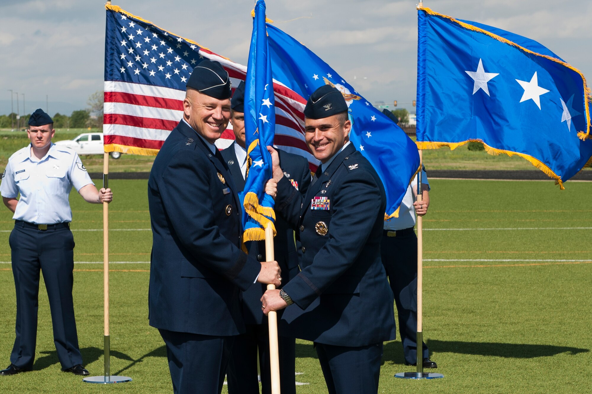 Col. John Wagner, 460th Space Wing commander, right, accepts command of the 460th SW from Lt. Gen. John W. “Jay” Raymond, U.S. Strategic Command's Joint Functional Component Command for Space and 14th Air Force (Air Forces Strategic) commander, left, during the change of command ceremony June 12, 2014, at the all-purpose field on Buckley Air Force Base, Colo. Wagner became the commander of the 460th SW after service for two years as the 614th Air and Space Operations Center Commander and Joint Space Operations Center director in Vandenberg AFB, Calif. (U.S. Air Force photo by Senior Airman Phillip Houk/Released)