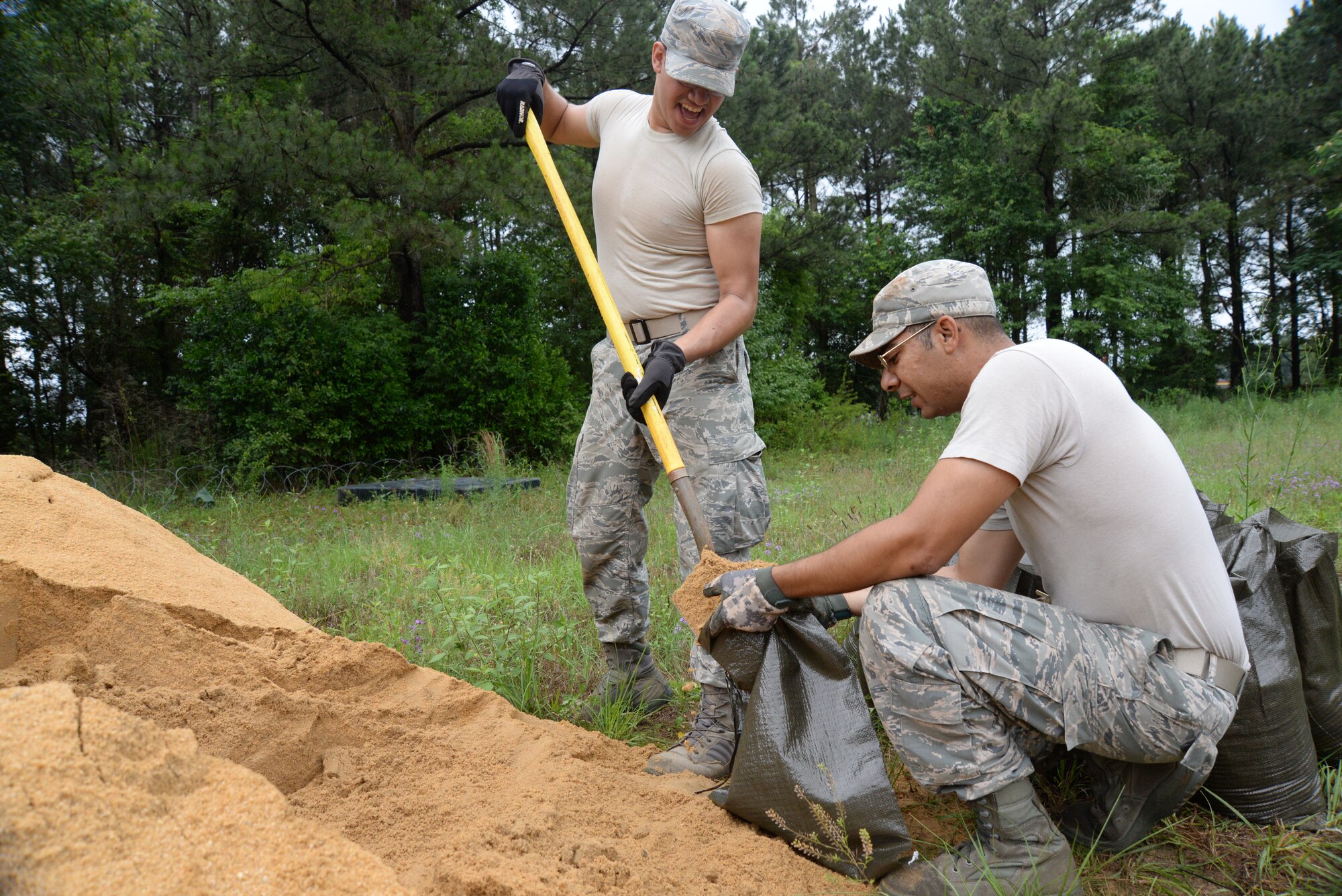 [From left] U.S. Air Force Airman 1st Class Daniel Santiago and Staff Sgt. William Gautrau, 20th Civil Engineer Squadron electrical systems specialists, fill bags of sand at Shaw Air Force Base, S.C., June 12, 2014. Many 20th CES flights, to include Explosive Ordnance Disposal, the fire department, Structures, power production, surveying and barriers all participated in the preparation for the exercise. (U.S. Air Force photo by Airman 1st Class Michael A. Cossaboom/Released)